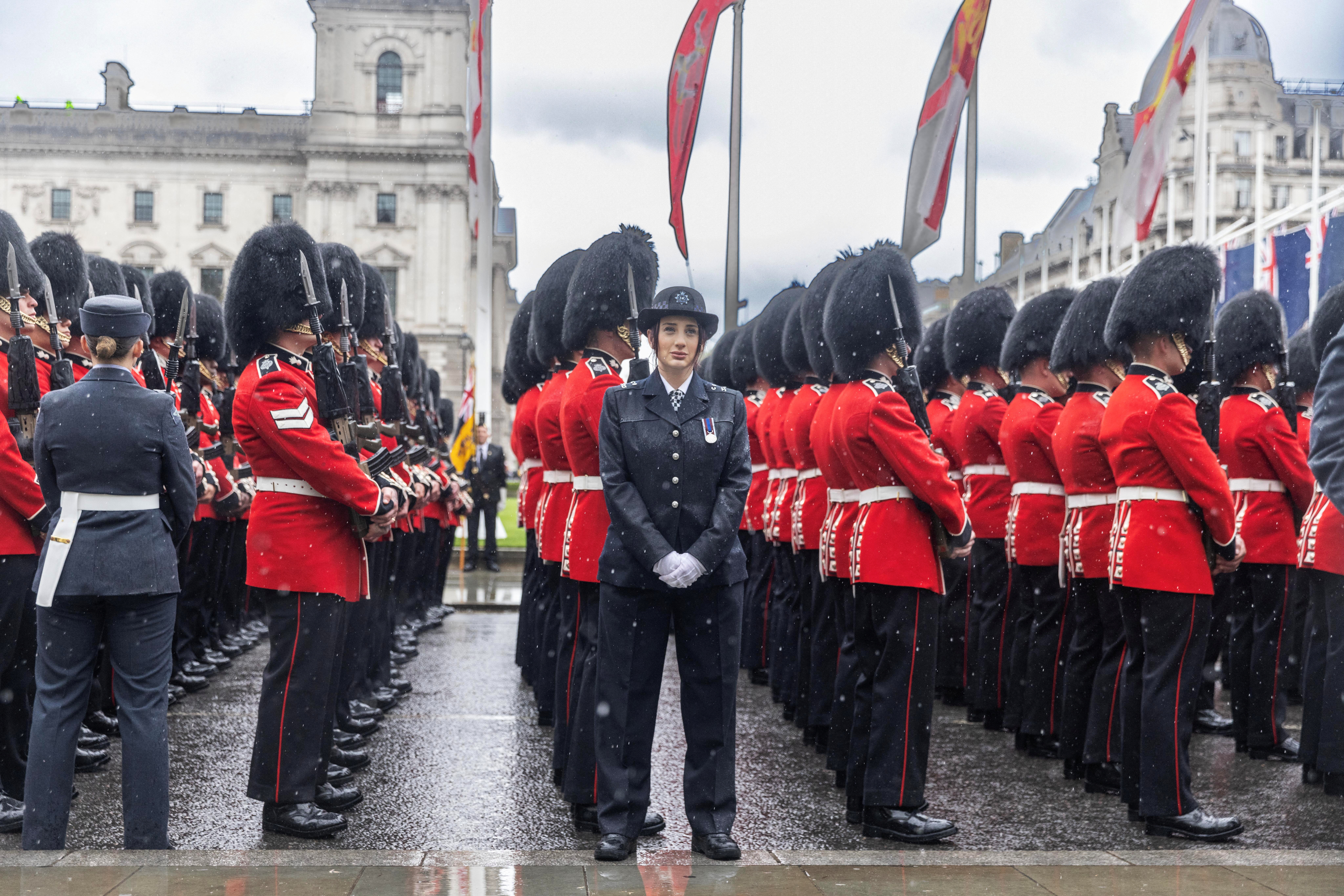 Policías y guardias ceremoniales esperan bajo la lluvia a que el rey Carlos y la reina Camila abandonen la Abadía de Westminster después de su coronación.  Jack Hill/Pool via REUTERS