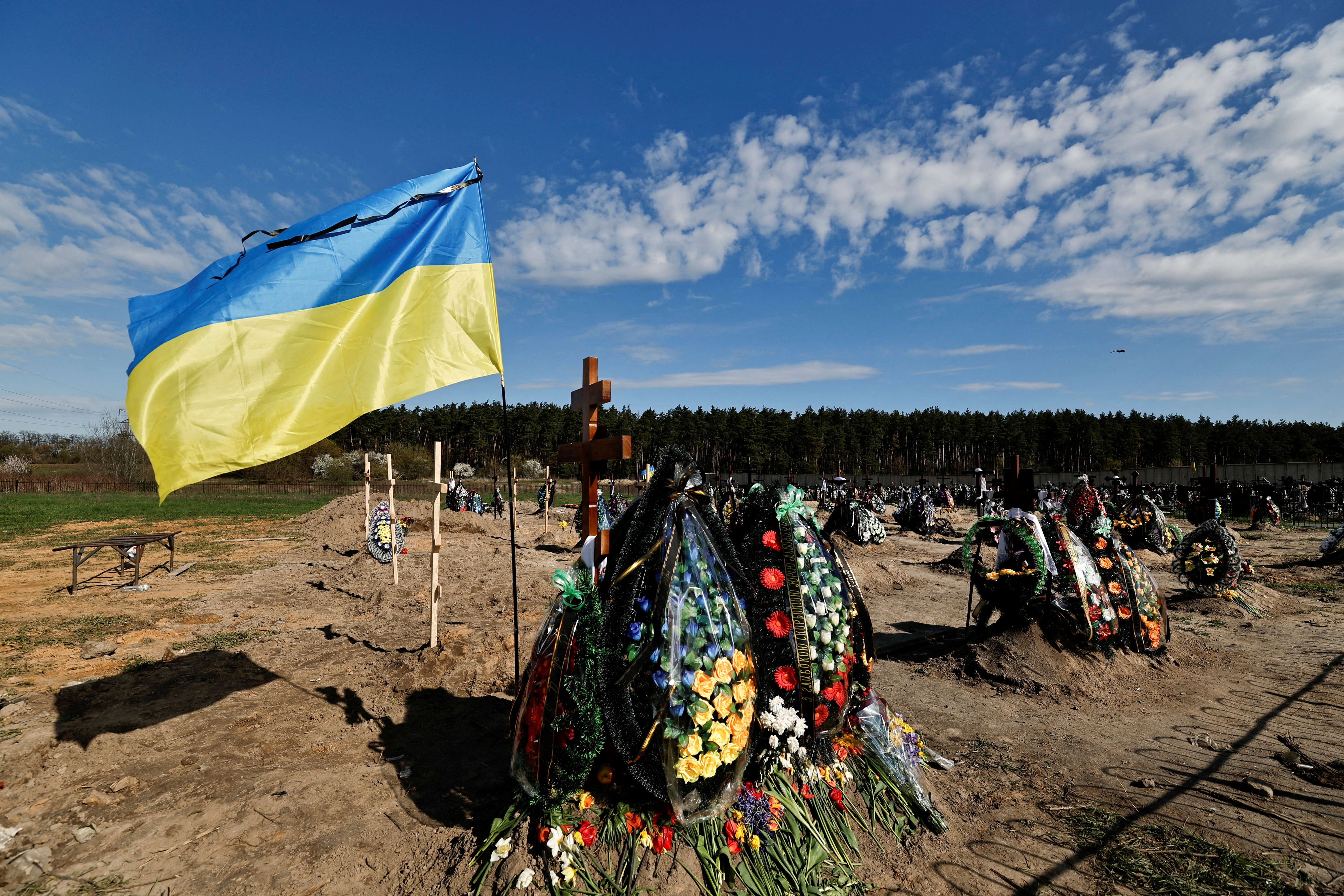FOTO DE ARCHIVO: La bandera de Ucrania se ve junto a las nuevas tumbas de las personas asesinadas durante la invasión rusa de Ucrania, en un cementerio en la región de Bucha Kyiv, Ucrania 28 de abril de 2022. REUTERS/Zohra Bensemra