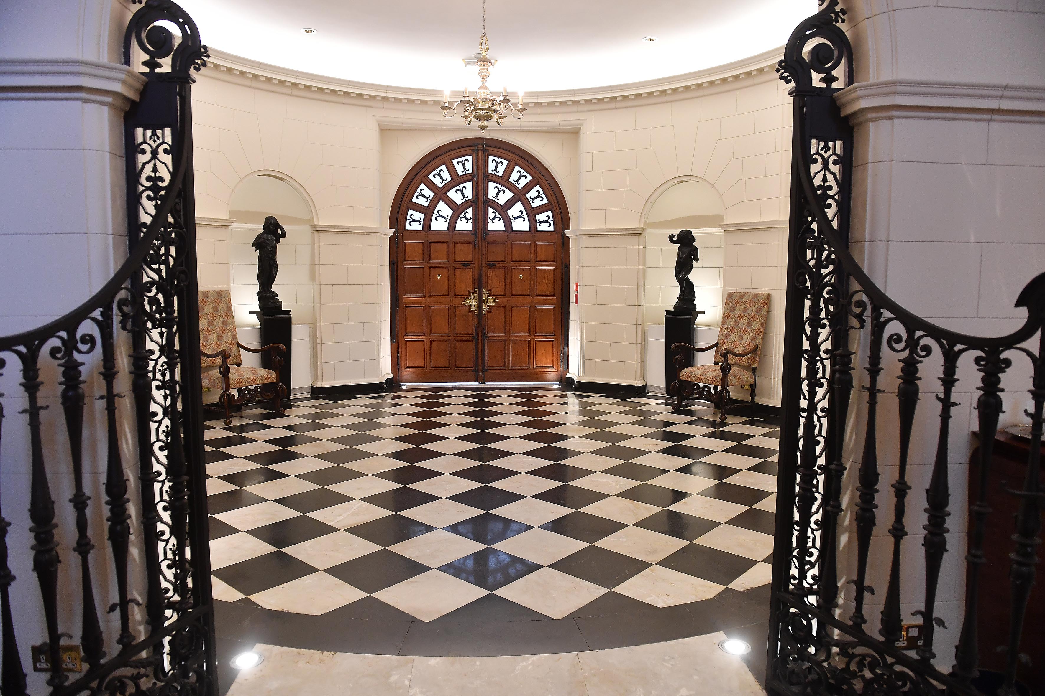 El vestíbulo, de planta circular y solado de diseño ajedrezado, se impone entre rejas de hierro forjado (Maximiliano Luna)