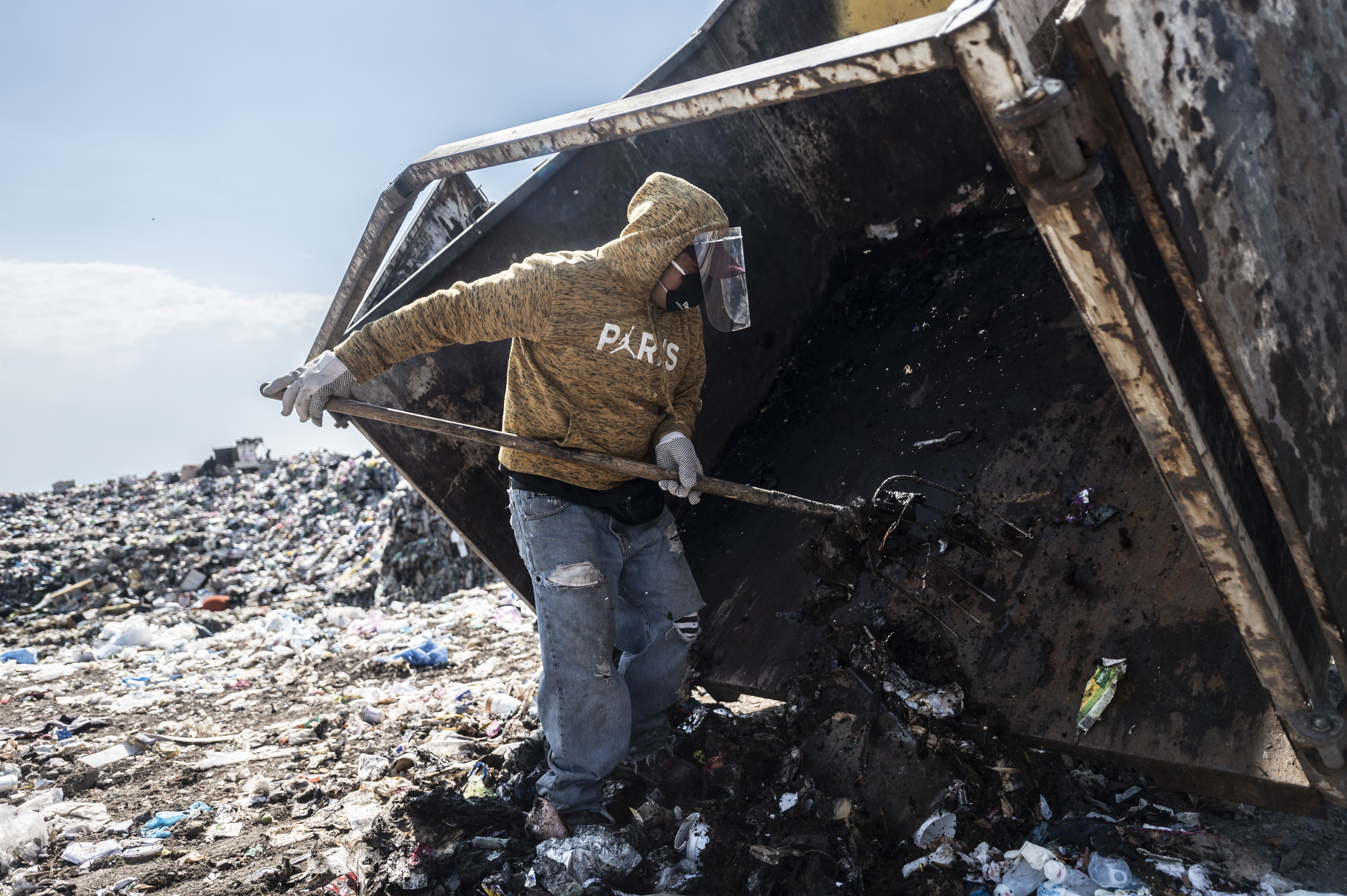 Un recolector de basura descarga desechos médicos en el basurero