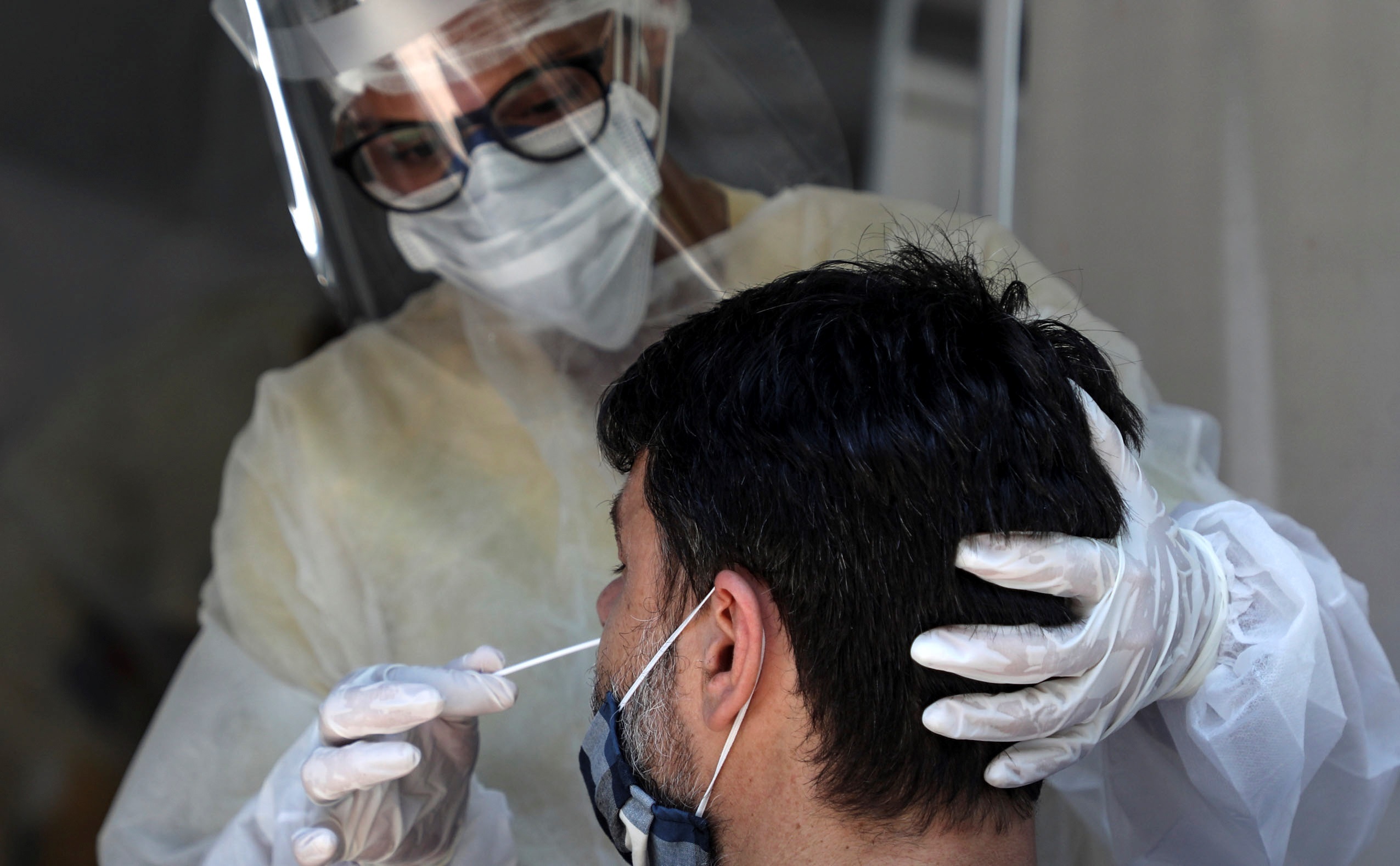 Personal médico le toma la prueba de coronavirus a un hombre en São Gonçalo, estado de Río de Janeiro (Brasil), en una fotografía de archivo. EFE/Fabio Motta
