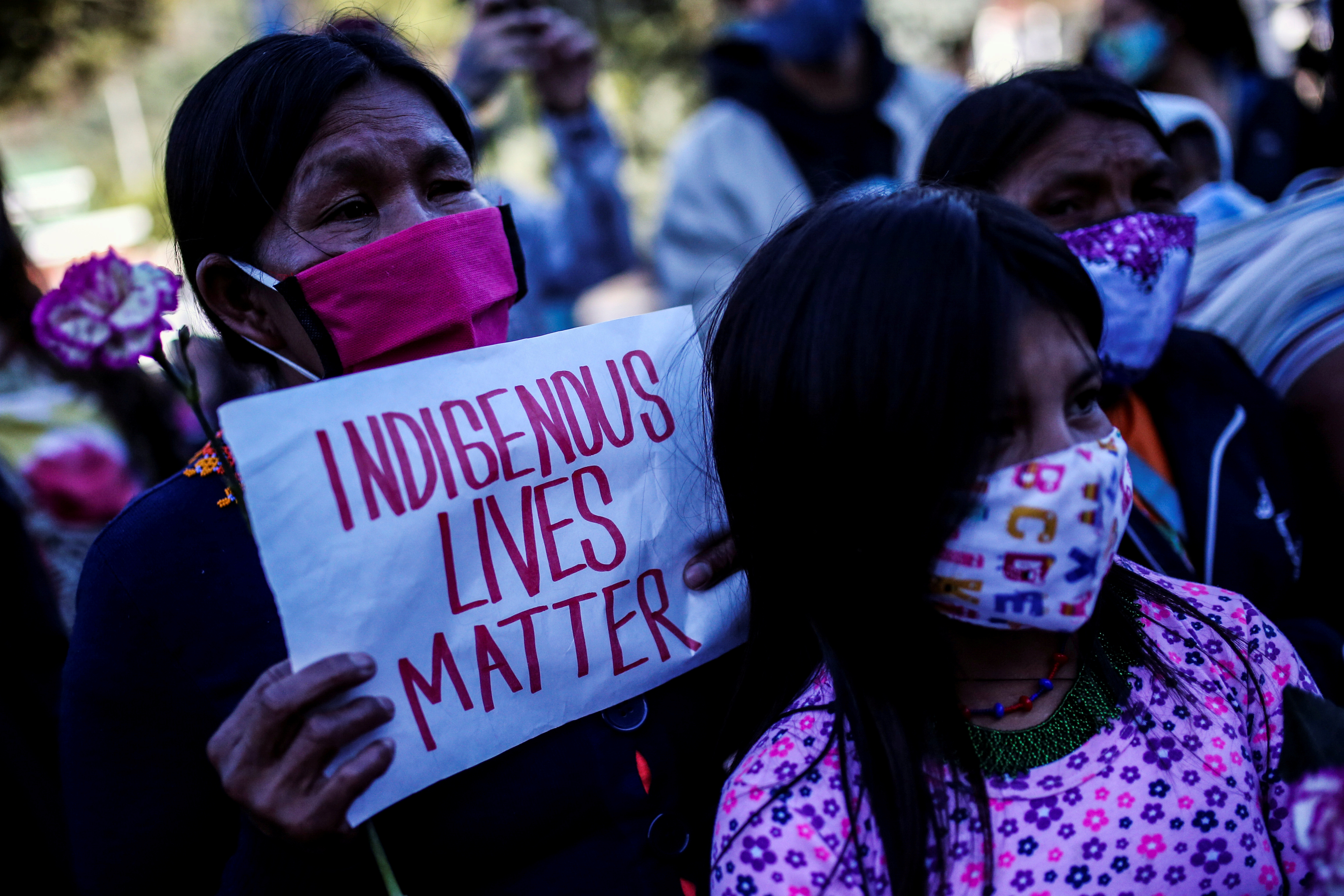 FILE PHOTO: Demonstrators wearing face masks protest in front of a military battalion, against the reported rape of an Embera Chami indigenous girl by soldiers, in Bogota, Colombia June 29, 2020. REUTERS/Luisa Gonzalez/File Photo