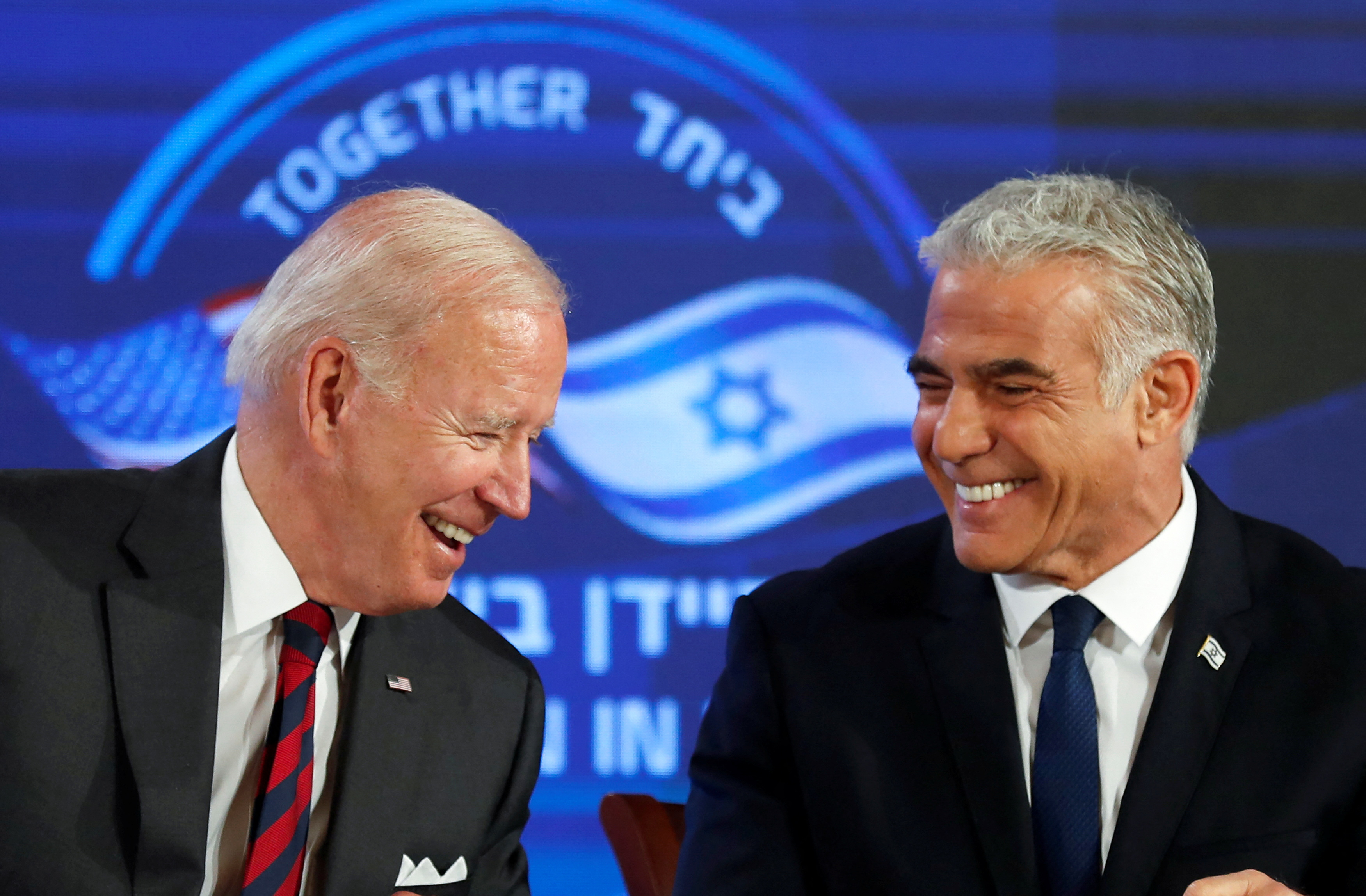 El presidente de Estados Unidos, Joe Biden, y el primer ministro israelí, Yair Lapid, reaccionan mientras firman un compromiso de seguridad en el hotel Waldorf Astoria en Jerusalén, Israel, el 14 de julio de 2022.  Atef Safadi/Pool vía REUTERS