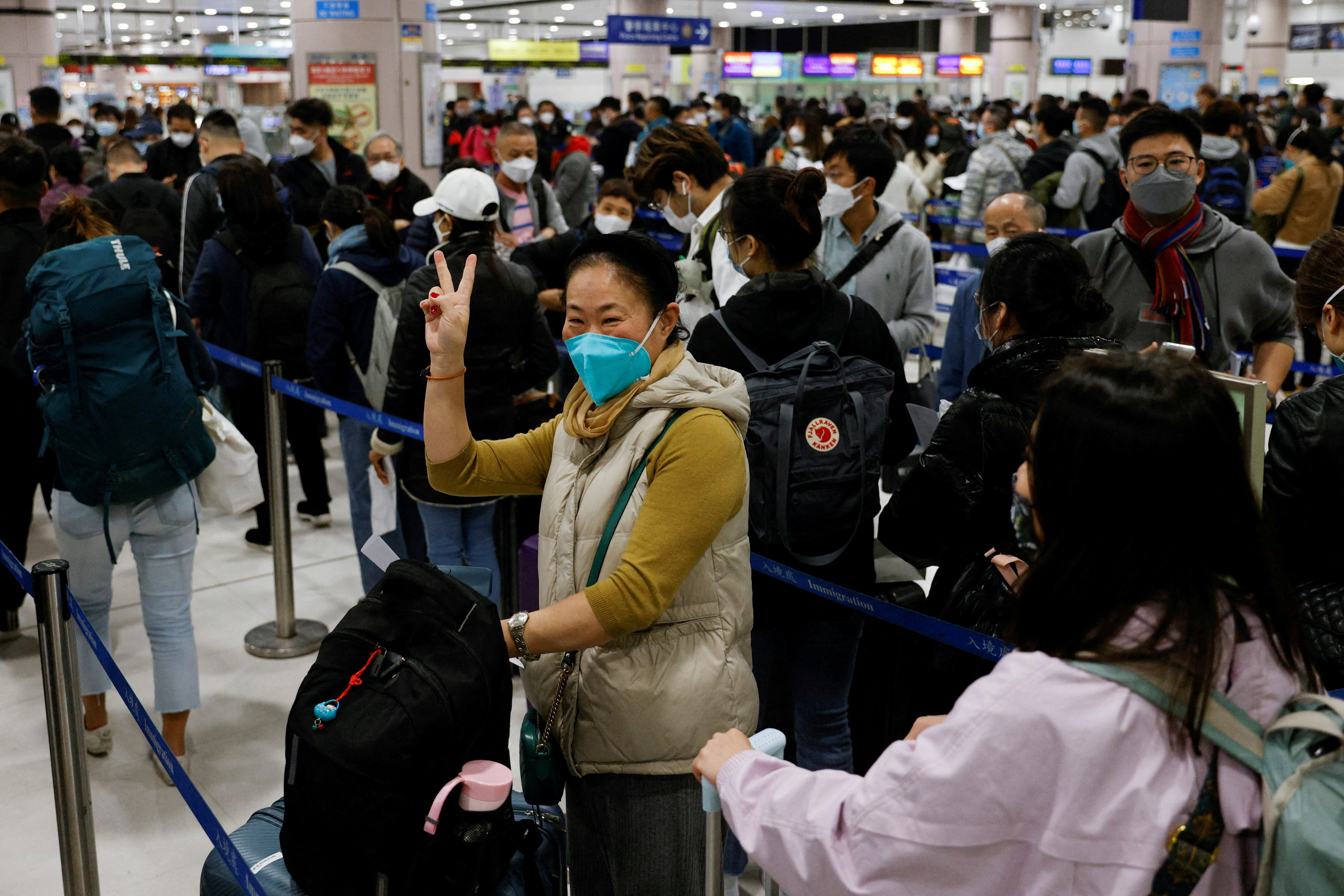 Una mujer celebra en el puesto de control fronterizo Lok Ma Chau de Hong Kong en el primer día en que China reabre la frontera en medio de la pandemia de la enfermedad por coronavirus (COVID-19) en Hong Kong, China, 8 de enero de 2023. REUTERS/Tyrone Siu