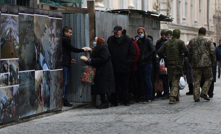 Varias personas reciben alimentos al exterior de la iglesia de San Pedro y San Pablo en Leópolis, Ucrania