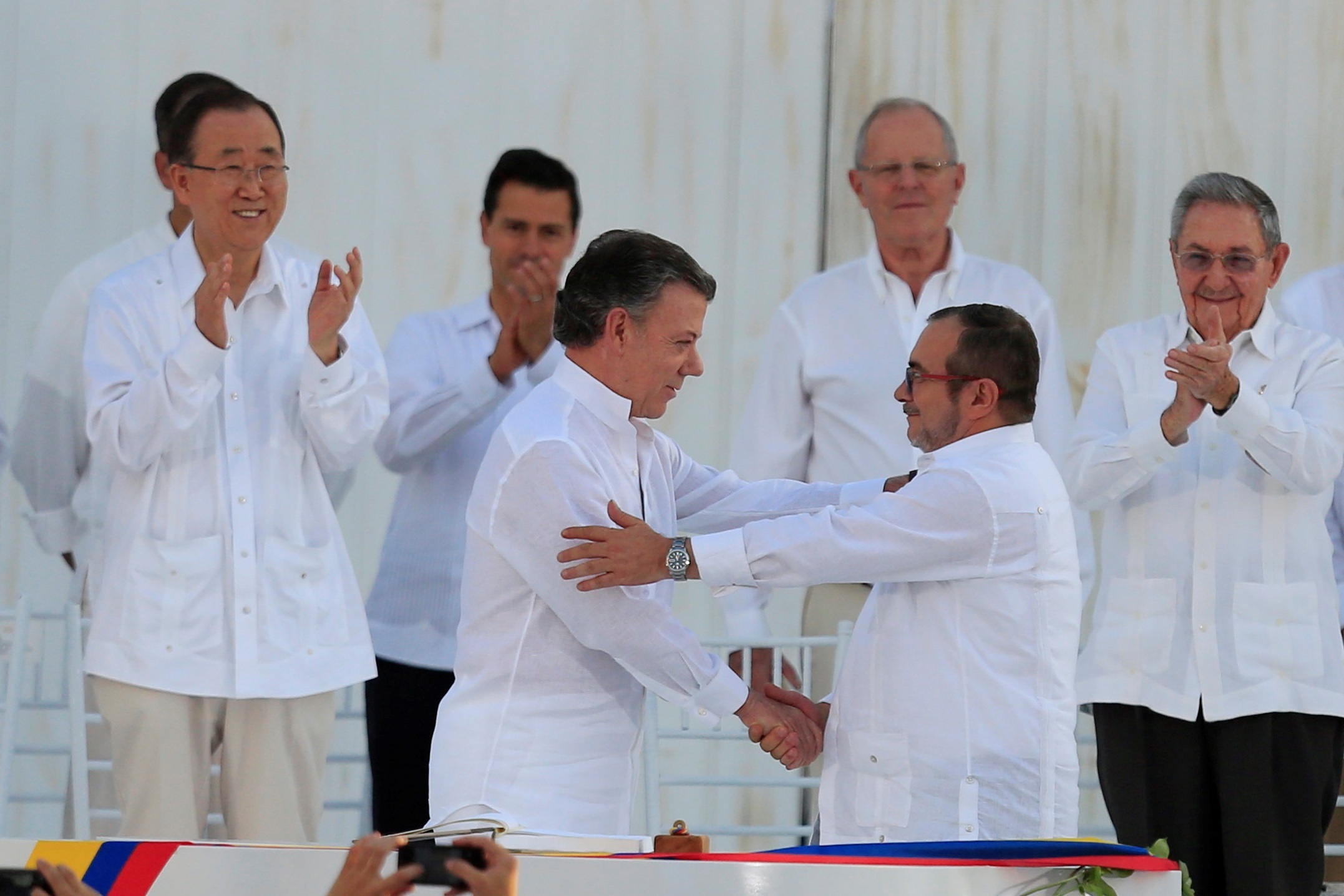 El presidente de Colombia, Juan Manuel Santos (c-i) y el máximo líder de las FARC, Rodrigo Londoño(c-d), alias "Timochenko", se saludan tras firmar el acuerdo de paz, el 26 de septiembre de 2016, en Cartagena (Colombia). EFE/Ricardo Maldonado
