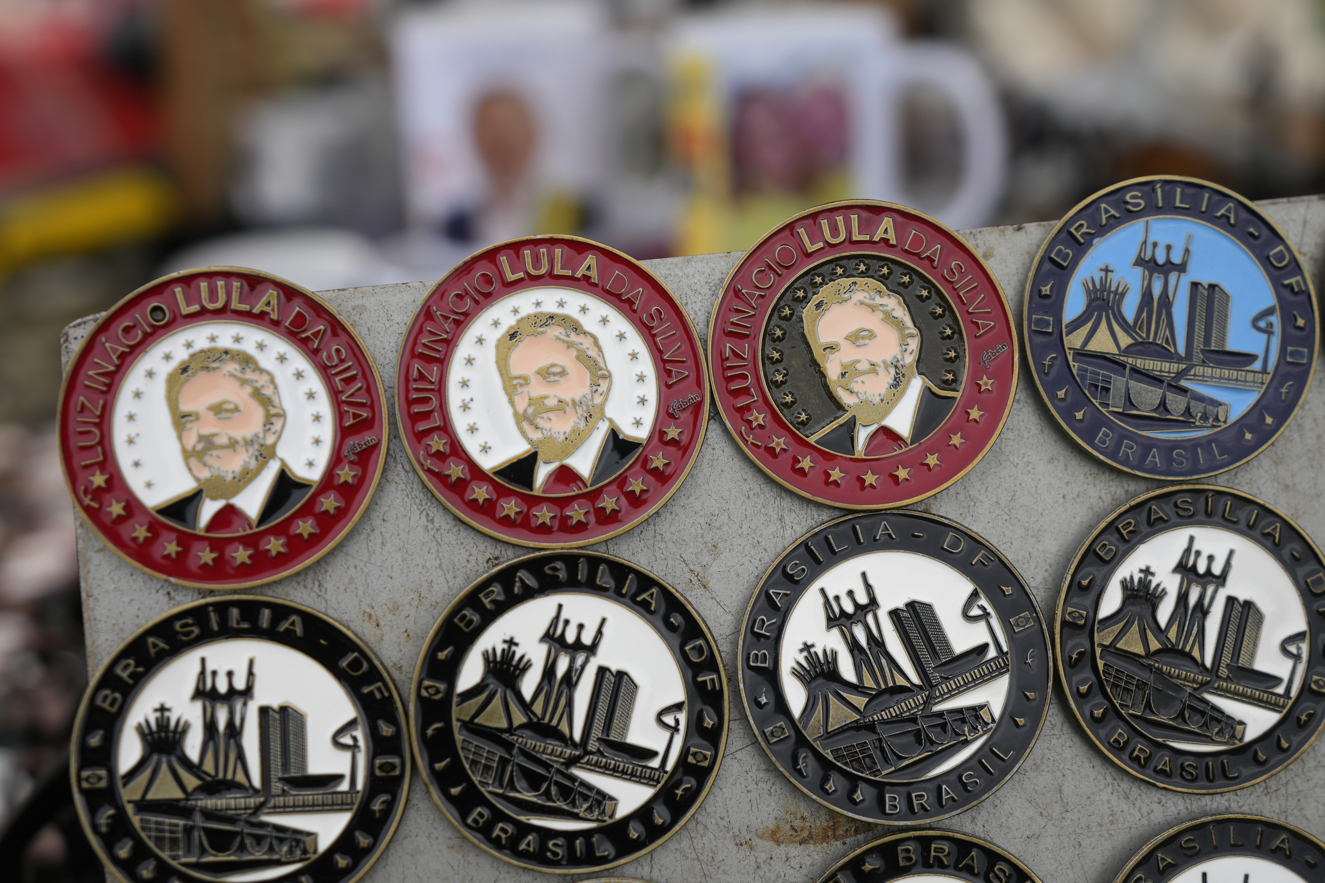 Chapas de recuerdo con la imagen del presidente electo de Brasil, Luiz Inácio Lula da Silva, a la venta en Brasilia, Brasil, el 31 de diciembre de 2022, en la Explanada de los Ministerios, donde se celebrará su toma de posesión el 1 de enero de 2023. (AP Foto/Eraldo Peres)