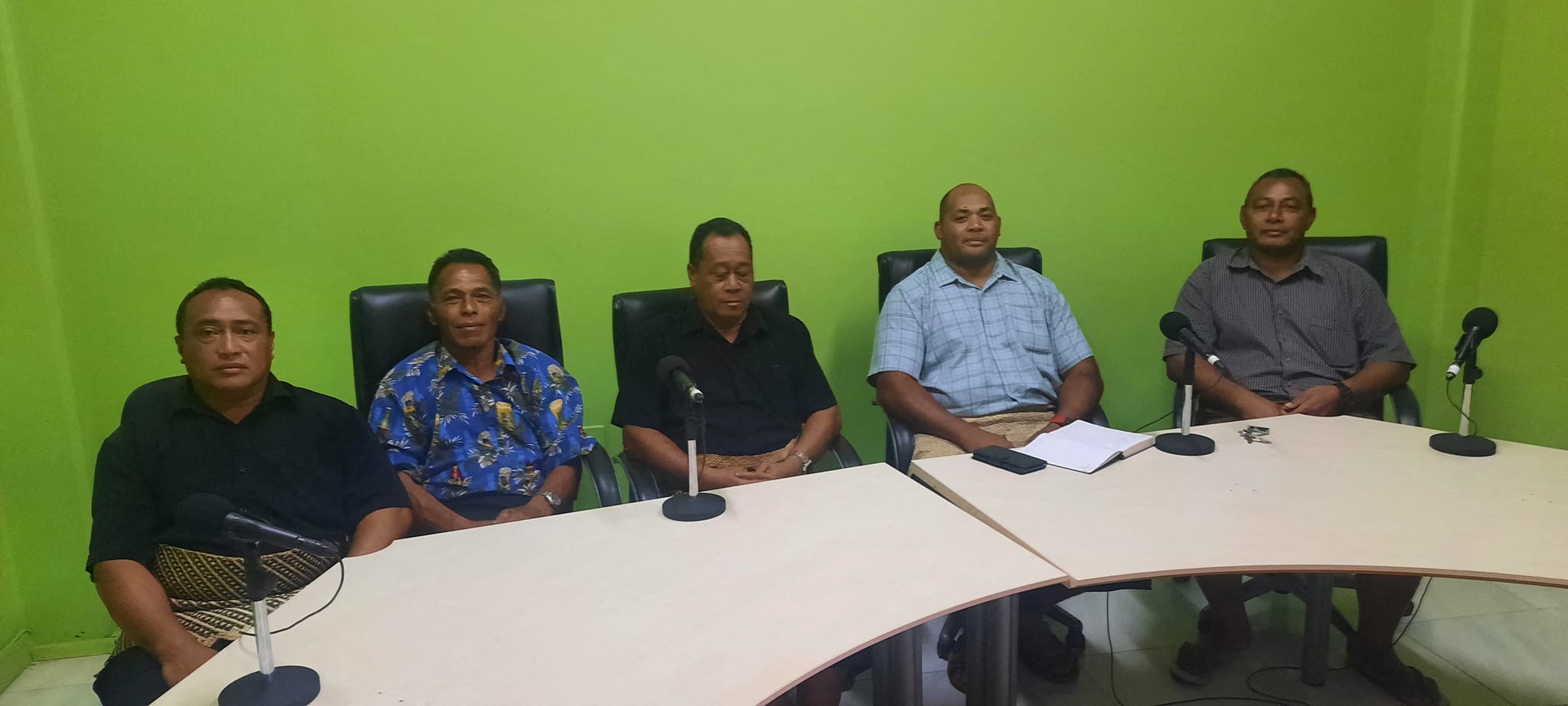 Lisala Folau, sentado segundo desde la izquierda con una camisa azul con dibujos, comparece ante la prensa en Tonga para relatar su historia (Marian Kupu/ Broadcom Broadcasting FM87.5/REUTERS)