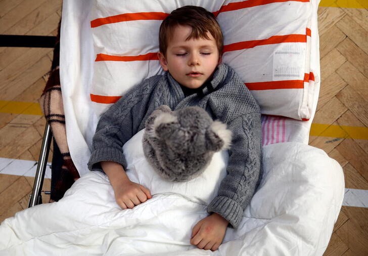 El refugiado ucraniano Misha Goloborodko, de 4 años y procedente de Irpín, descansa en un albergue instalado en la Escuela Primaria No.5 de Przemysl, Polonia. 21 marzo 2022. REUTERS/Hannah McKay