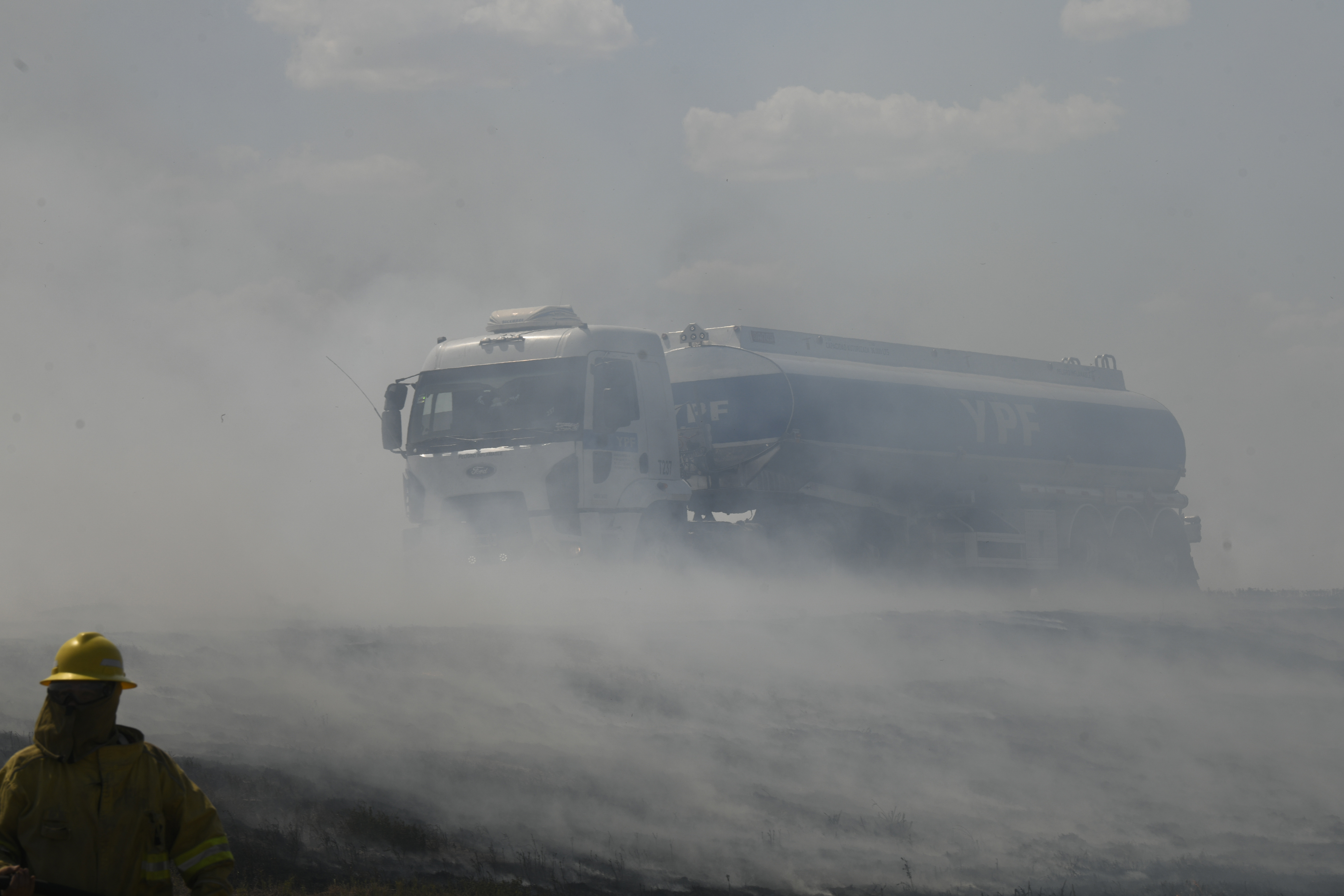 Un camión avanza a través del humo de los incendios de maleza en la autopista de Rosario-Santa Fe en Barrancas, en la provincia de Santa Fe, Argentina, el martes 17 de enero de 2023. (AP Foto/Gustavo Garello)