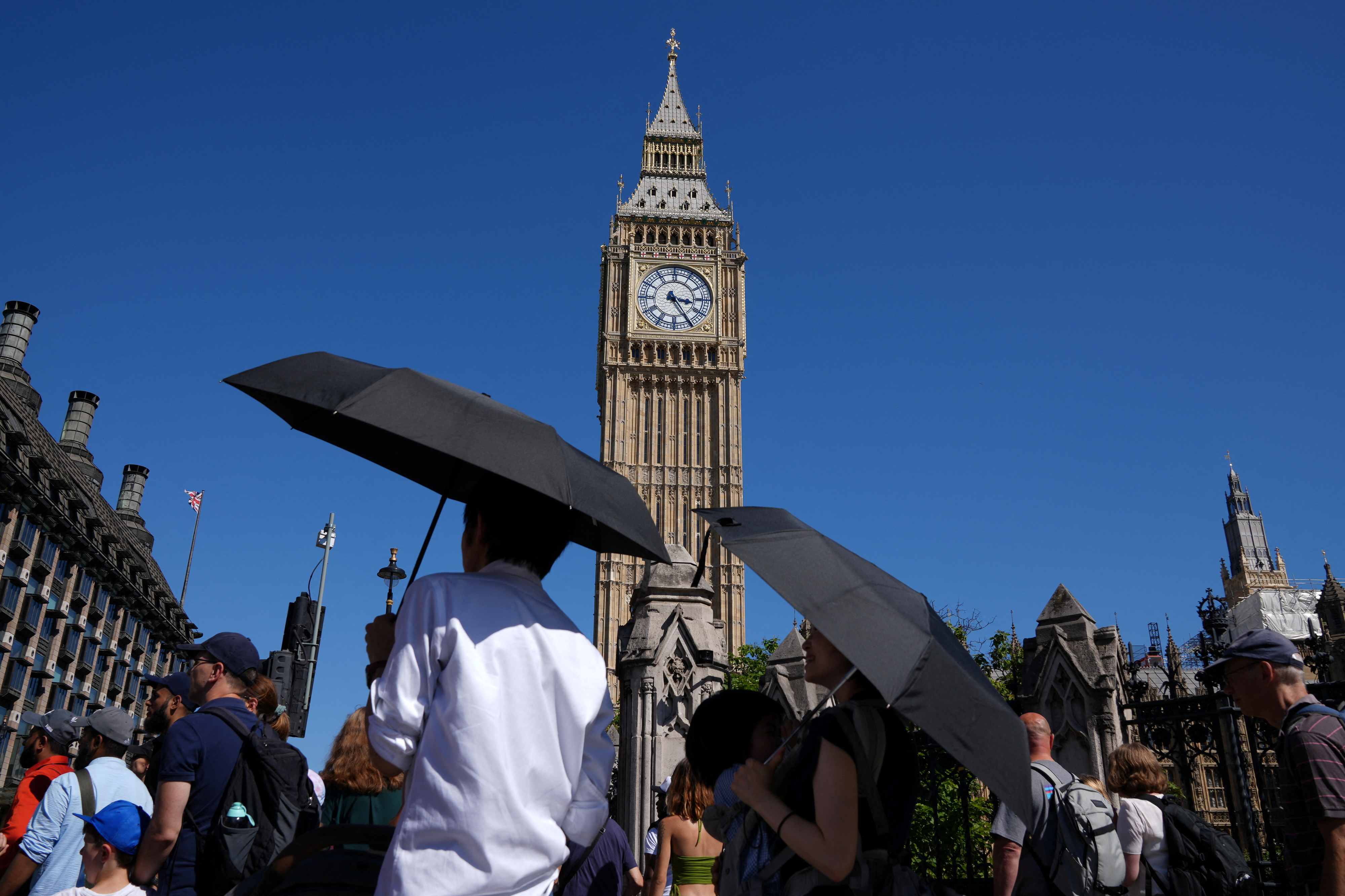 La gente se protege del sol con paraguas en la Plaza del Parlamento, mientras continúa el calor, en Londres, Gran Bretaña 10 de agosto de 2022. REUTERS/Maja Smiejkowska