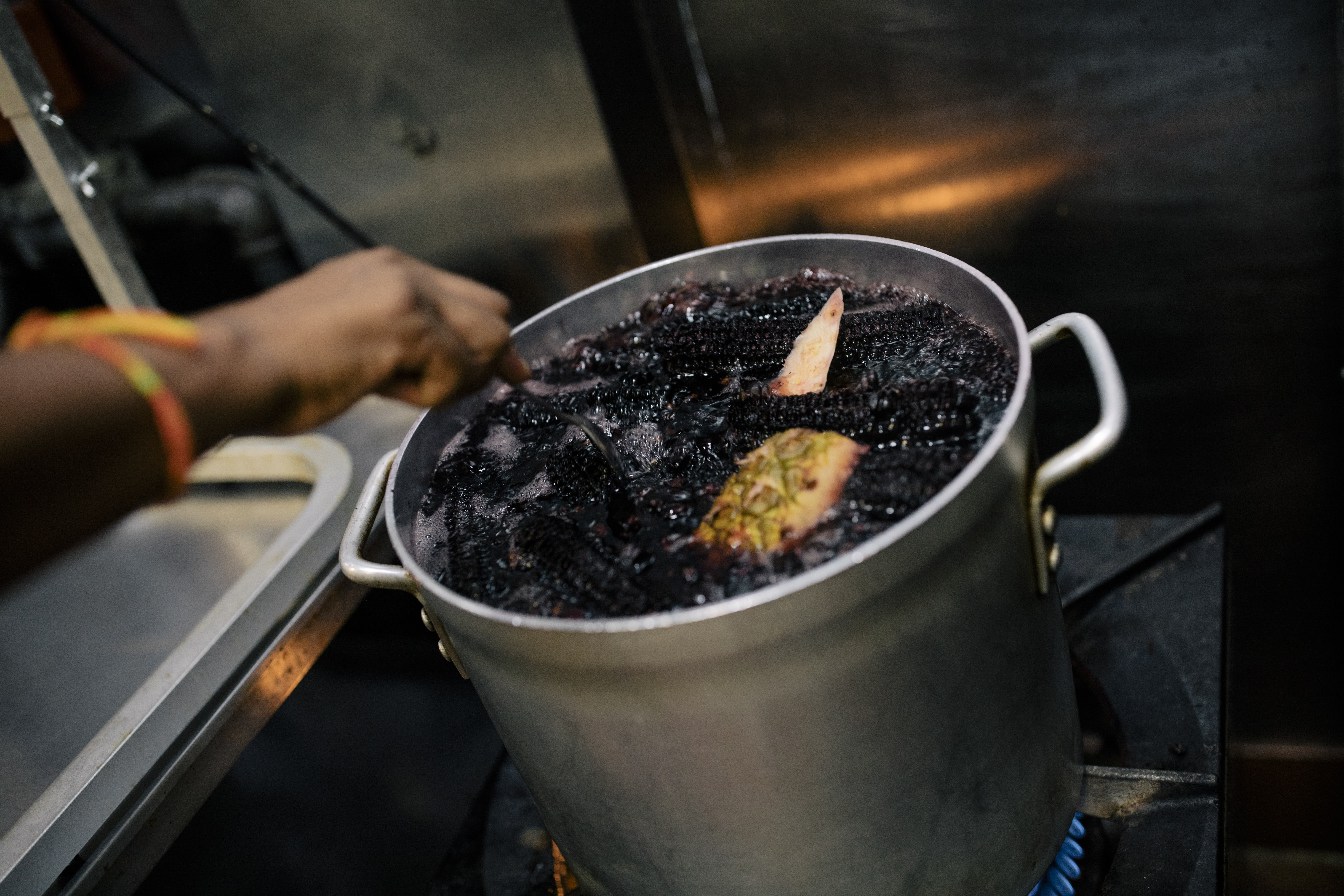 The chicha morada simmers in a large pot with purple corn and pineapple shells for about two hours.