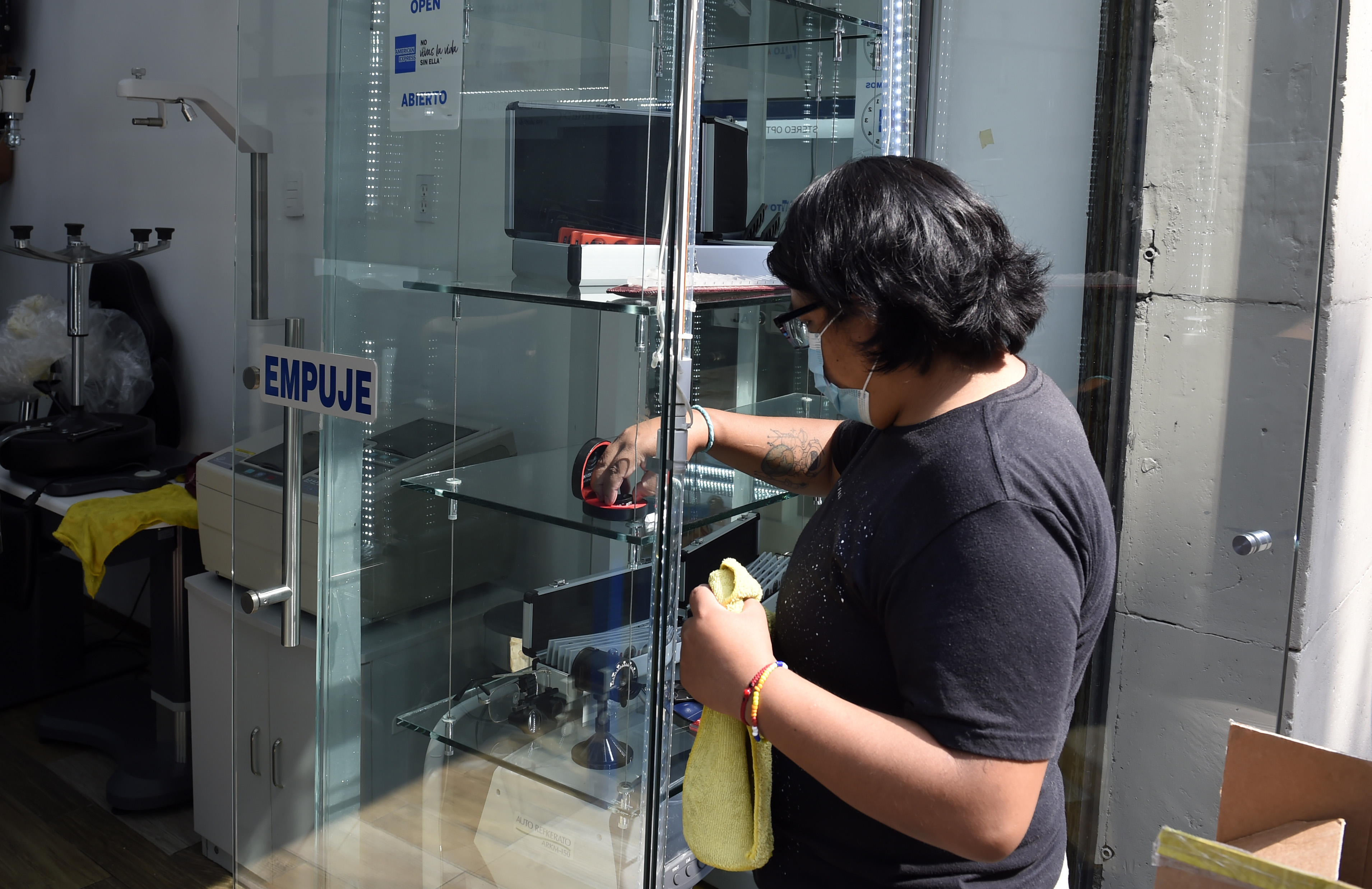 El empleado de una óptica limpia antes de volver a abrir en la Ciudad de México el 29 de junio de 2020 durante la pandemia de COVID-19.(Foto: ALFREDO ESTRELLA / AFP)