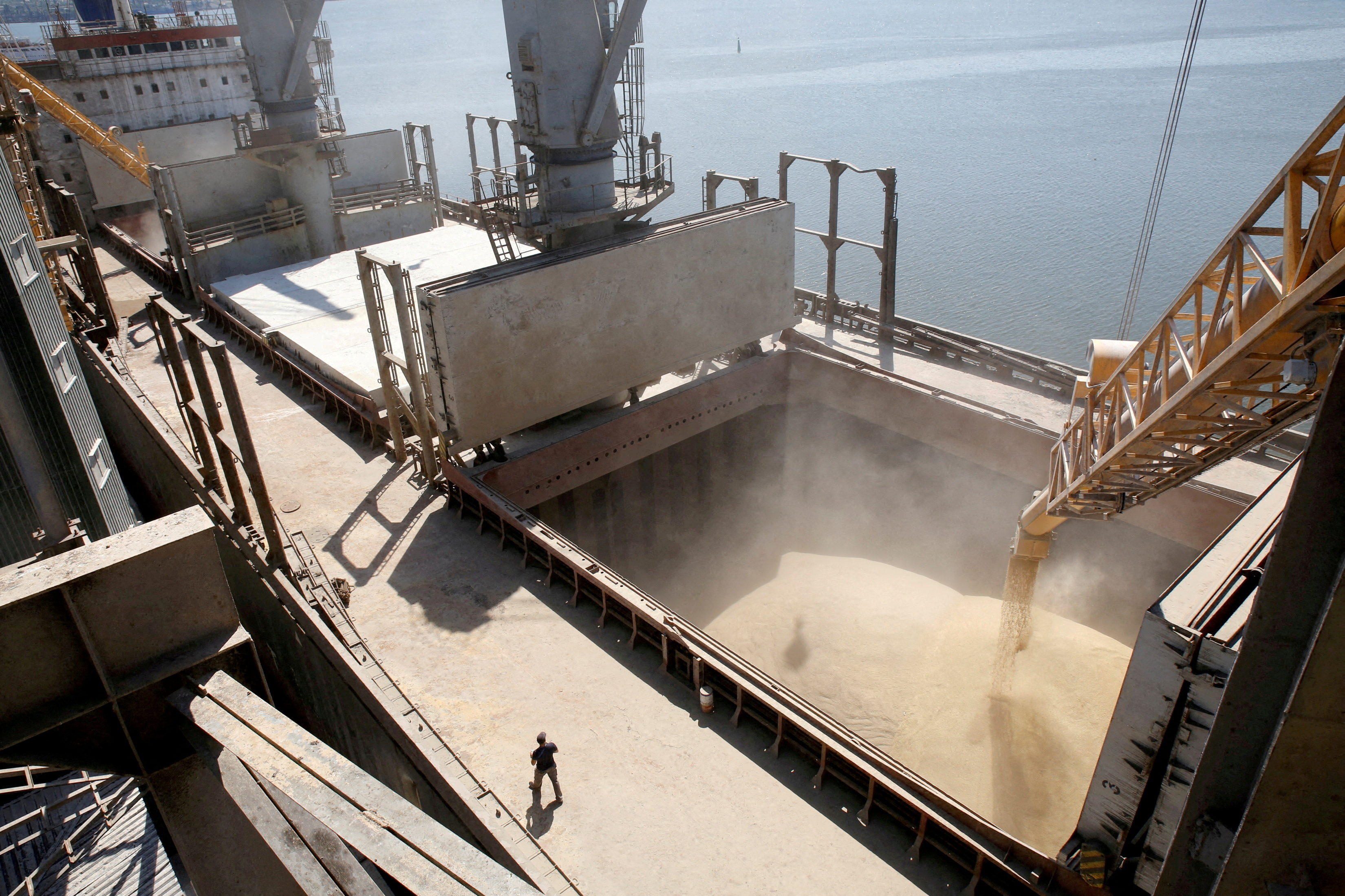 Un trabajador del astillero observa cómo se vierte mecánicamente el grano de cebada en un barco de 40.000 toneladas en la terminal de envíos de un exportador agrícola ucraniano en la ciudad de Nikolaev, al sur de Ucrania (REUTERS/Vincent Mundy)