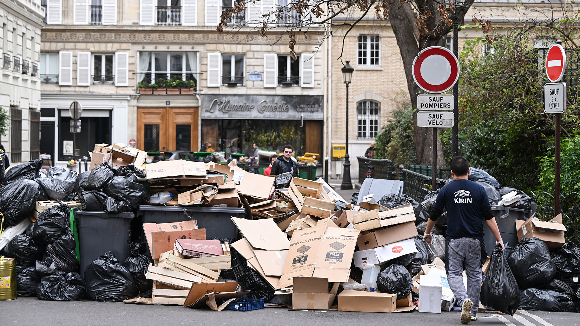 Contenedores de basura domésticos en una calle de París que se han estado acumulando desde que los recolectores se declararon en huelga contra la reforma de pensiones propuesta por el gobierno francés el 6 de marzo de 2023. (Foto de Stefano RELLANDINI / AFP)
