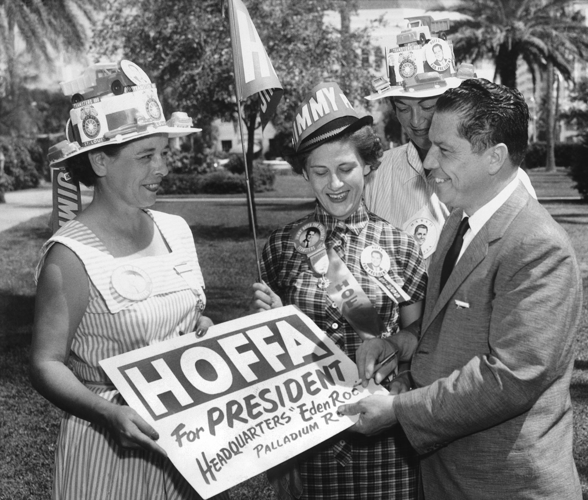 Teamsters union vice president JImmy Hoffa autographs a placard for him for a group of women campaigning for his run for president of the Teamsters, Miami Beach, Florida, October 1, 1957 (Photo by Underwood Archives/Getty Images)