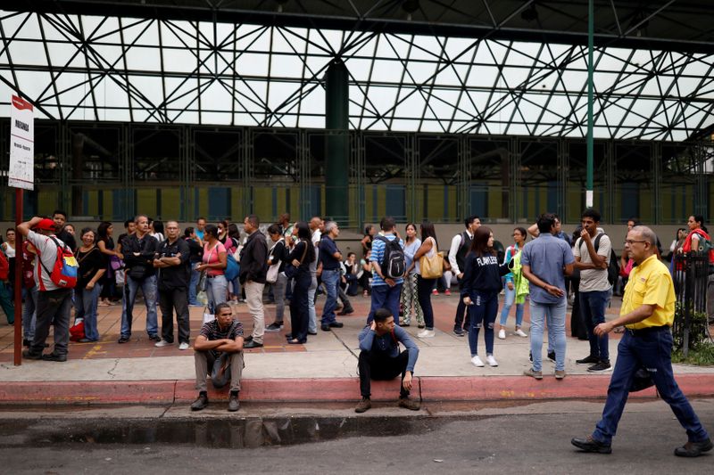 La gente espera frente a una estación de metro cerrada durante un apagón en Caracas (REUTERS/Carlos García Rawlins/Archivo)