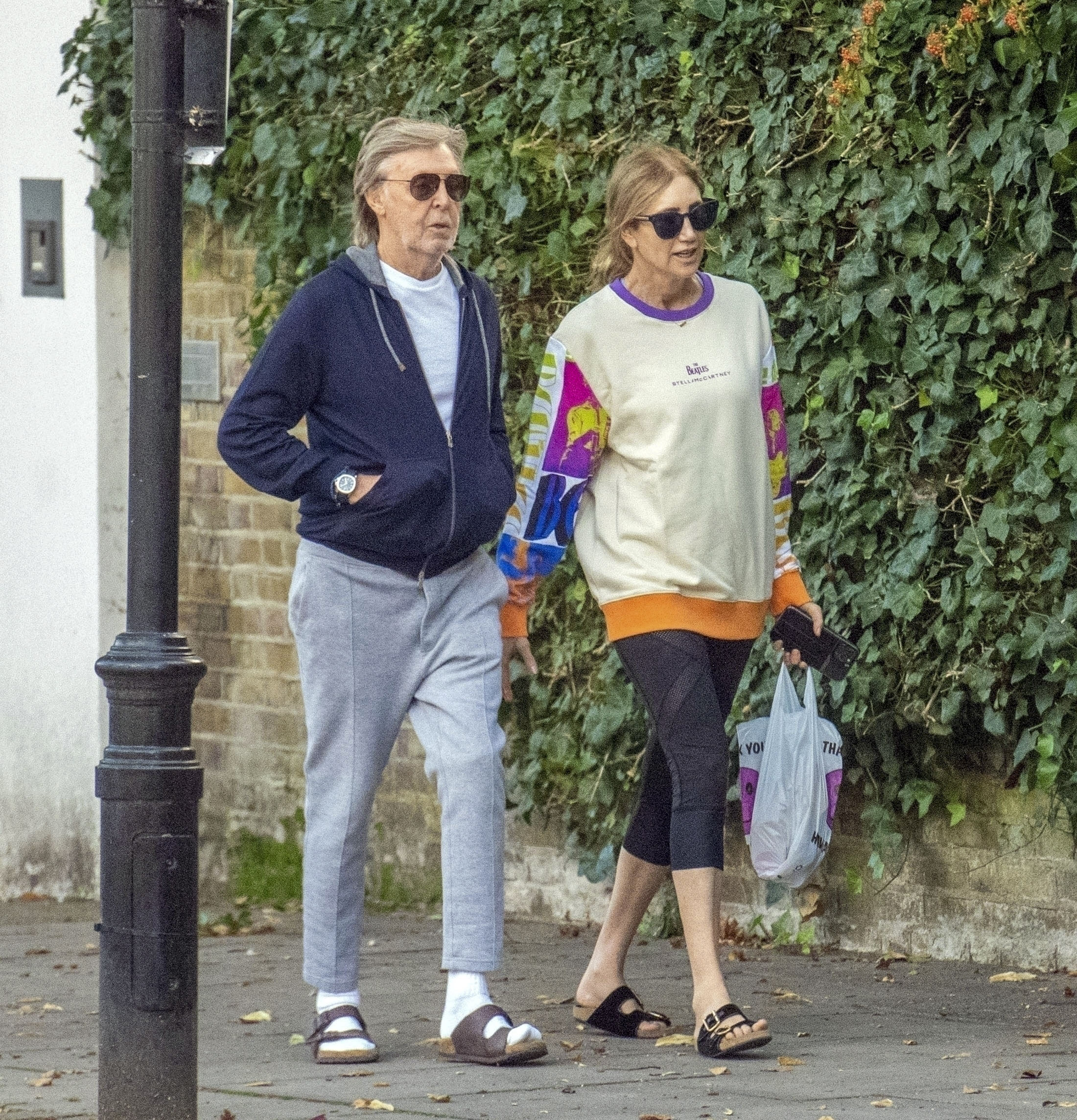 Paul McCartney and his wife, Nancy Shevell, took a walk through the streets of London.  Both were super informal, he in gray jogging, blue cotton jacket and Franciscan sandals with stockings and she in fisherman leggings, beige jumpsuit with colorful details and sandals.