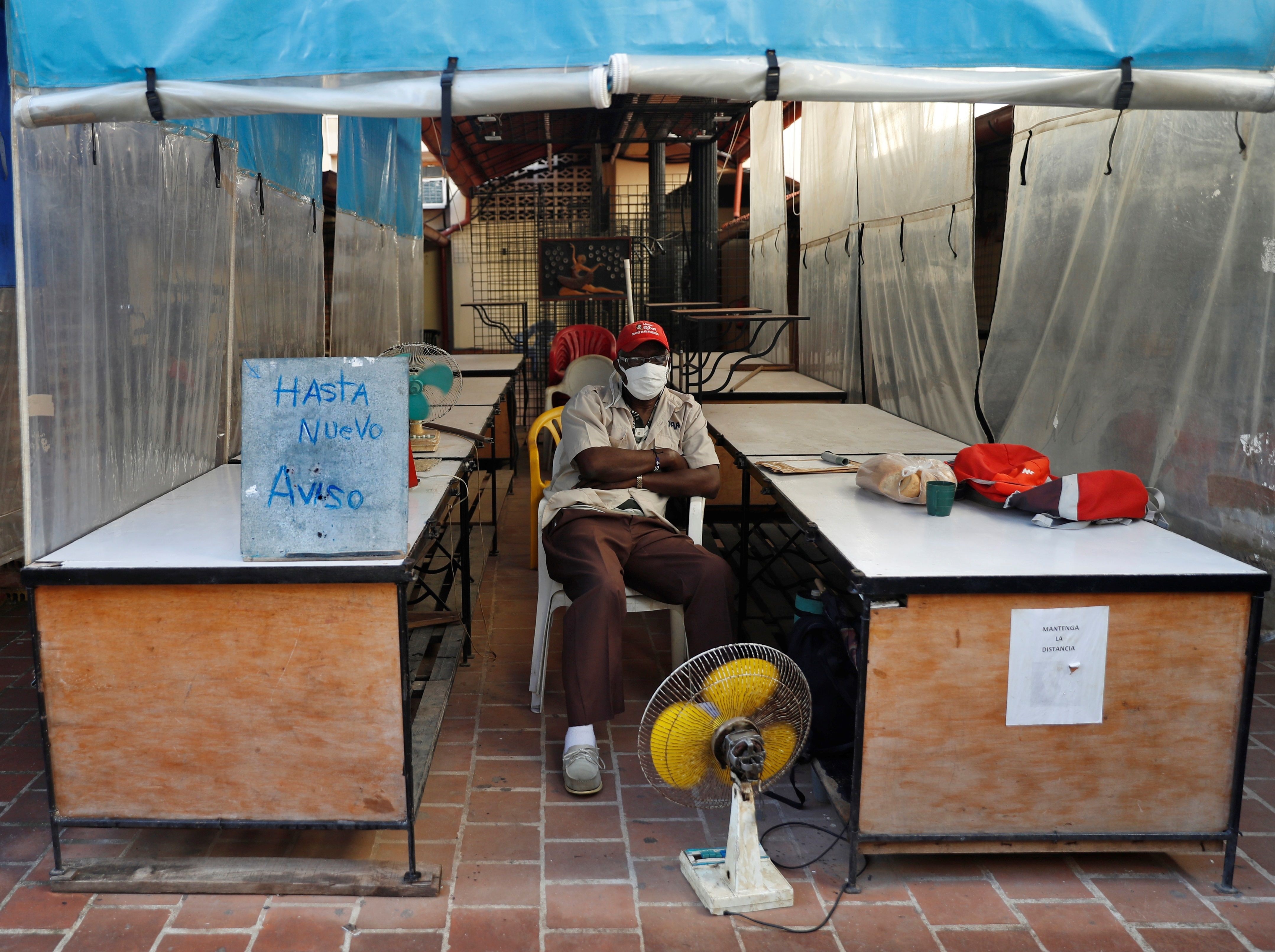 Un hombre custodia el local sede de la feria de calle Obispo, cerrada "hasta nuevo aviso", en La Habana (Cuba).
