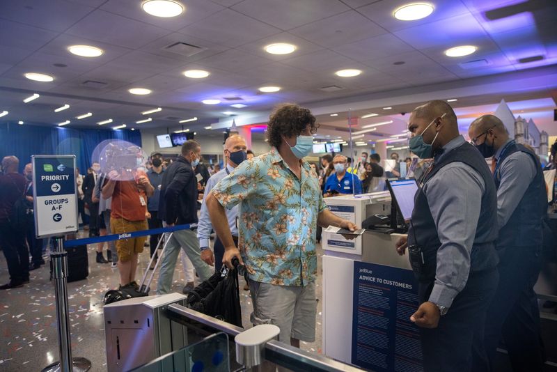 Foto de archivo: Un pasajero muestra su pasaporte en el aeropuerto internacional JFK en Estados Unidos el 11 de agosto de 2021 (REUTERS/Jeenah Moon)