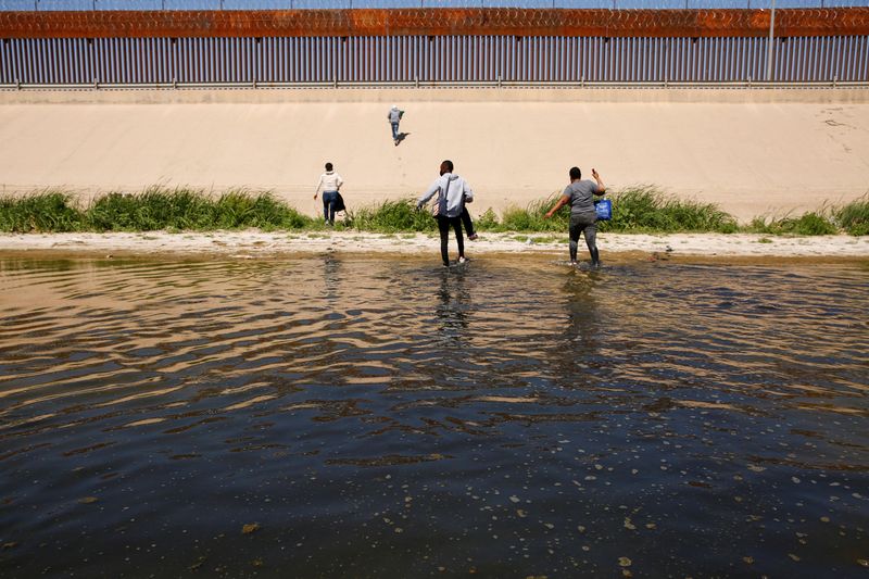Imagen de archivo de migrantes caminando por el río Bravo luego de cruzarlo para entregarse a agentes de la Patrulla Fronteriza de Estados Unidos para solicitar asilo en El Paso, Texas, Estados Unidos, vistos desde Ciudad Juárez, México. 13 de abril, 2022. REUTERS/Jose Luis Gonzalez