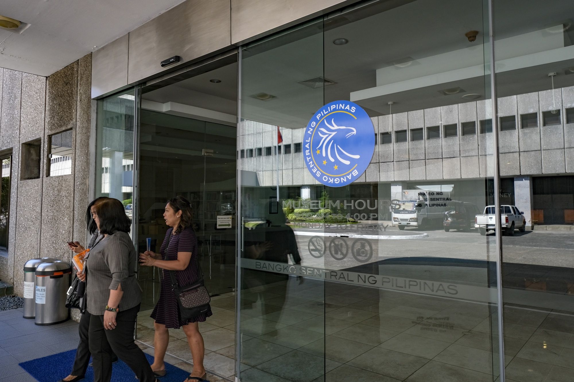 People exit the Bangko Sentral ng Pilipinas headquarters in Manila, the Philippines, on Thursday, Feb. 7, 2019. The Philippines central bank left its benchmark interest rate unchanged for a second straight policy meeting, while cutting inflation forecasts for this year and next. Photographer: Veejay Villafranca/Bloomberg