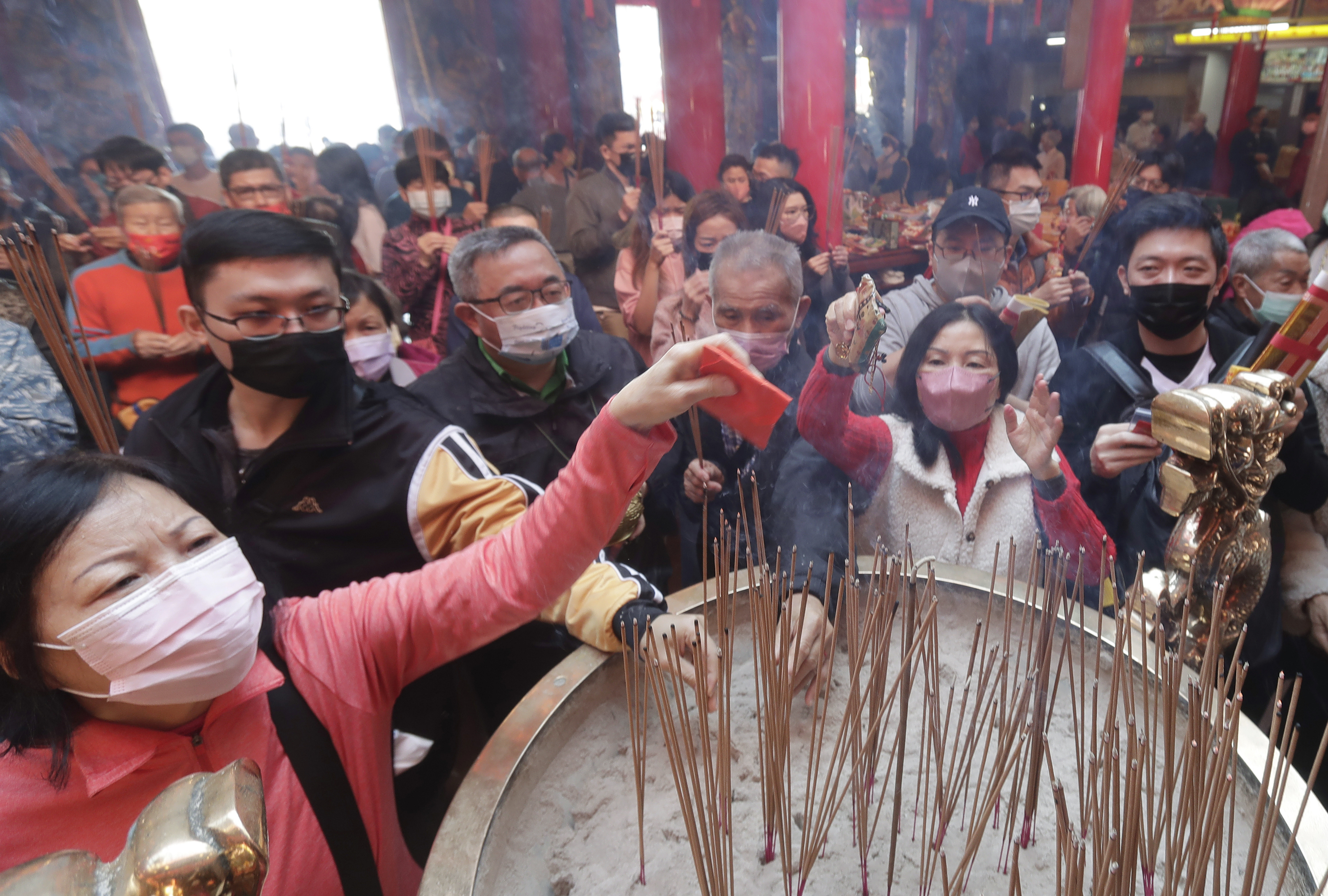 Worshipers wearing face masks to help combat the spread of the coronavirus pray for blessings at a temple on the first day of the Lunar New Year in Taipei, Taiwan, Sunday, Jan. 22, 2023. Each year is named after one of the 12 signs of the Chinese zodiac in a repeating cycle, and the one that begins is the Year of the Rabbit.  (AP Photo/Chiang Ying-ying)
