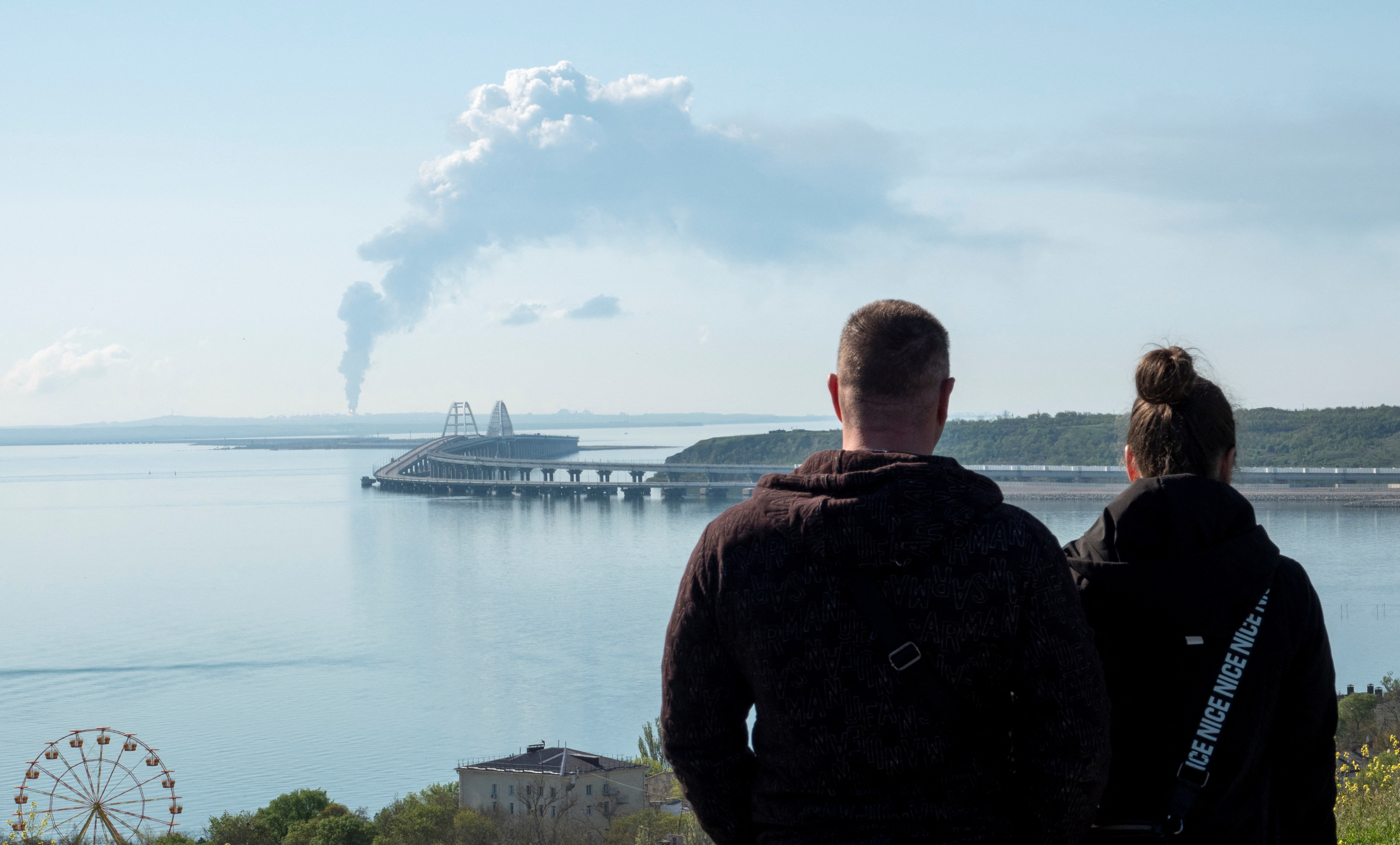 Una vista del estrecho de Kerch muestra el humo que se eleva sobre un depósito de combustible cerca del puente de Kerch en el pueblo de Volna. (REUTERS)