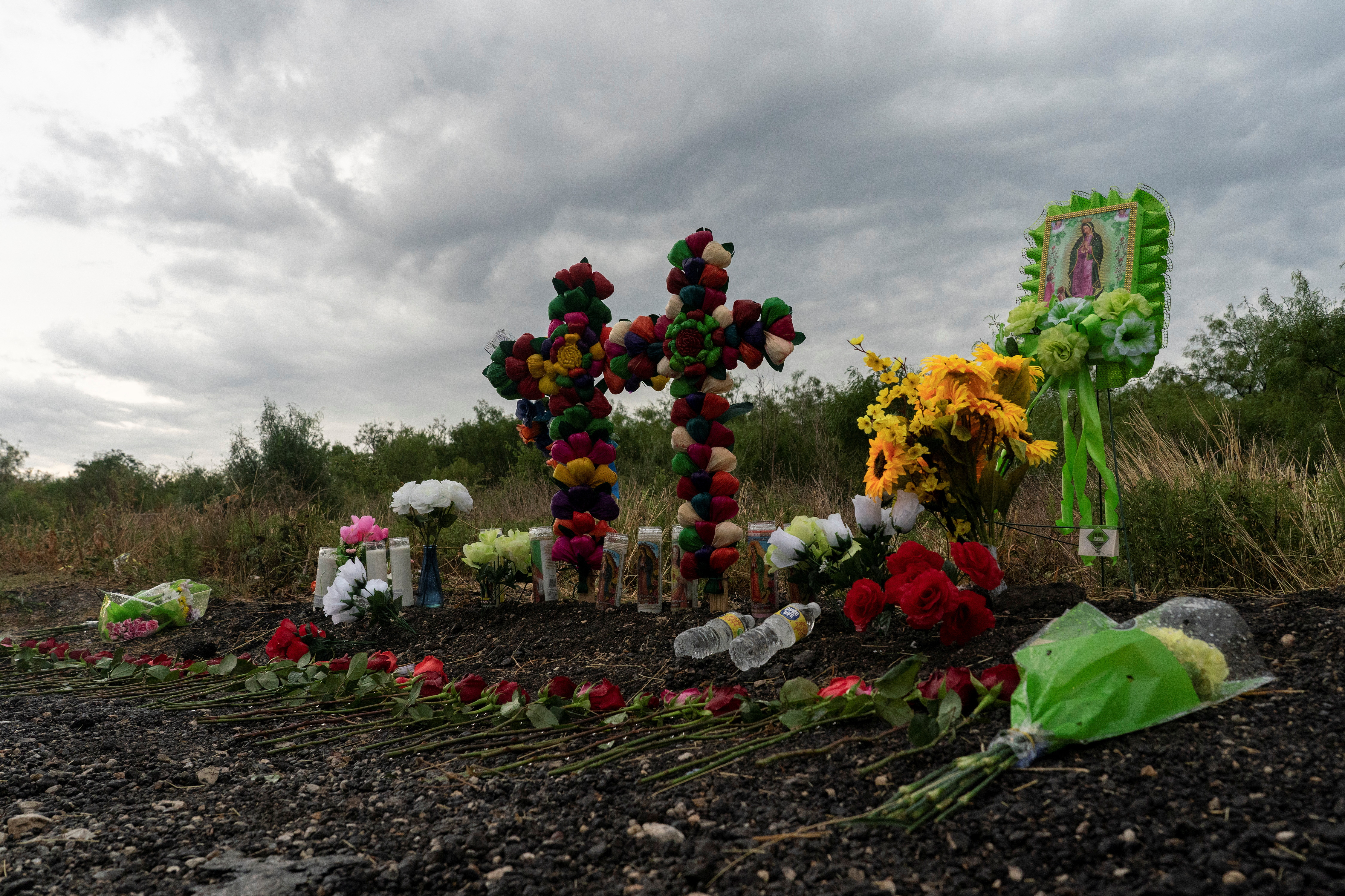 Flowers, candles, and water bottles are placed at the scene where dozens of migrants were found dead inside a trailer truck in San Antonio, Texas, U.S. June 28, 2022. REUTERS/Go Nakamura