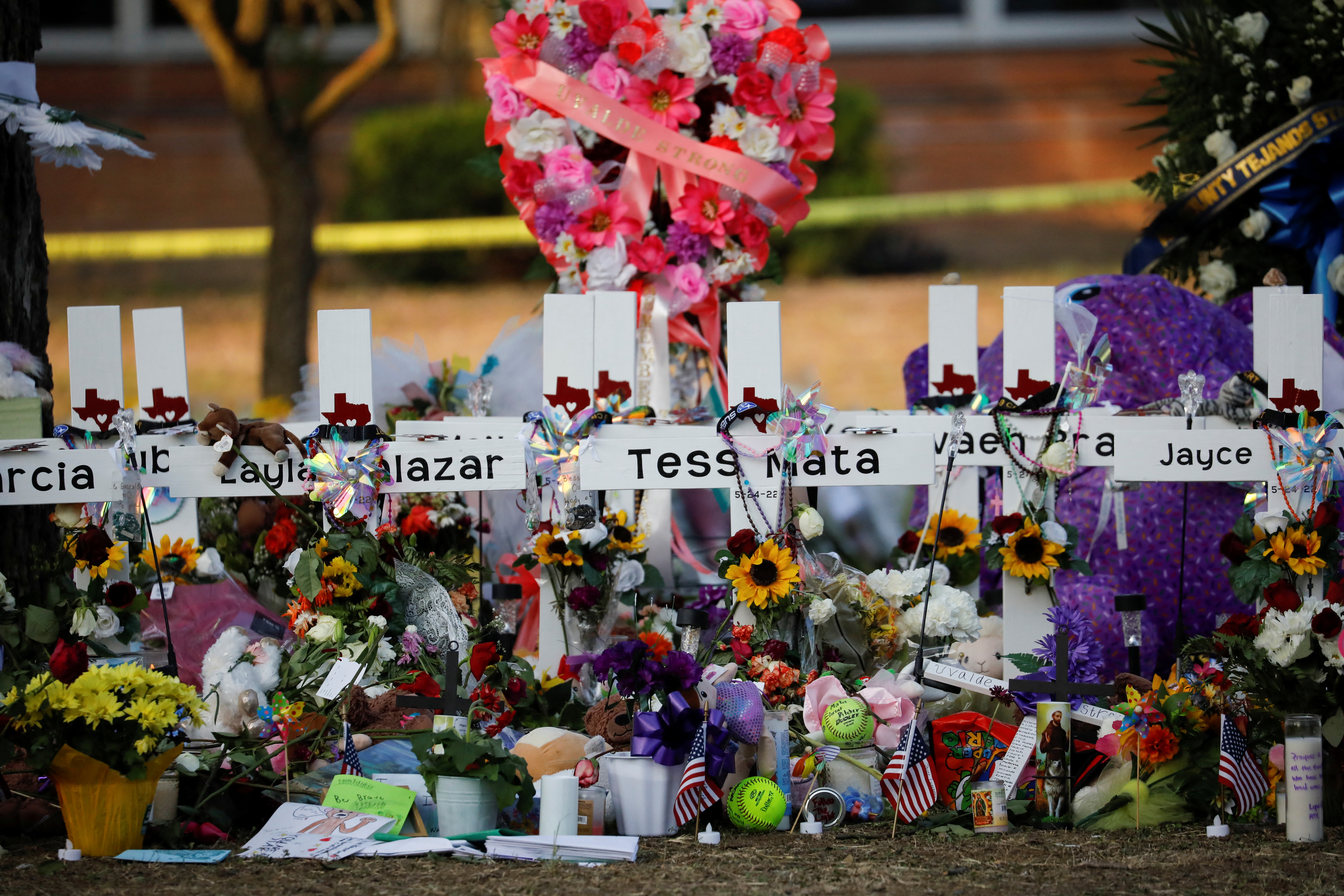 Flores, velas y fotos se dejan delante de cruces con los nombres de las víctimas del ataque en la escuela primaria Robb en Uvalde, Texas, el 28 de mayo de 2022 (REUTERS/Marco Bello)