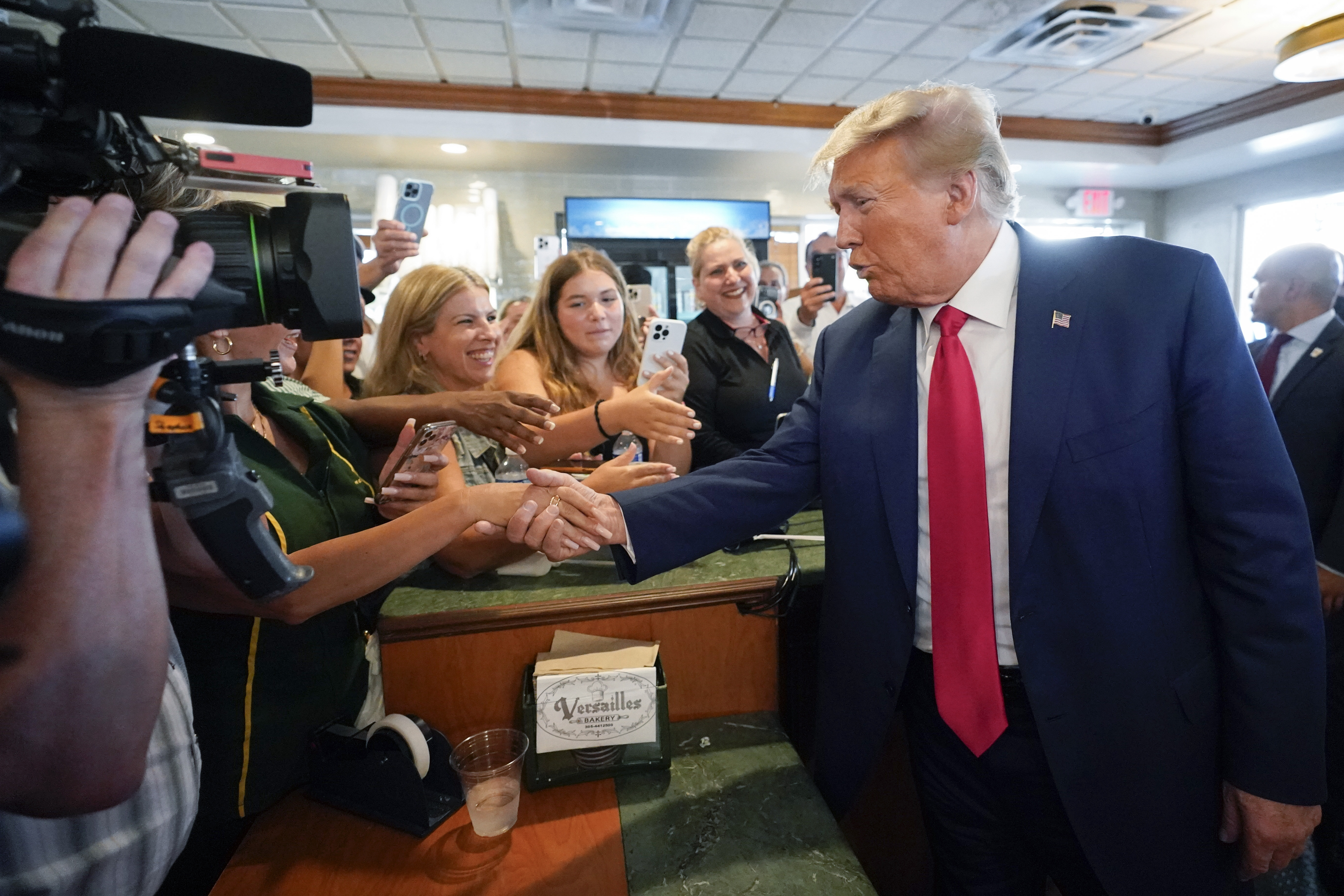 El expresidente Donald Trump saluda a sus seguidores en el restaurante cubano Versailles, en Miami, el martes 13 de junio de 2023. (AP Foto/Alex Brandon)