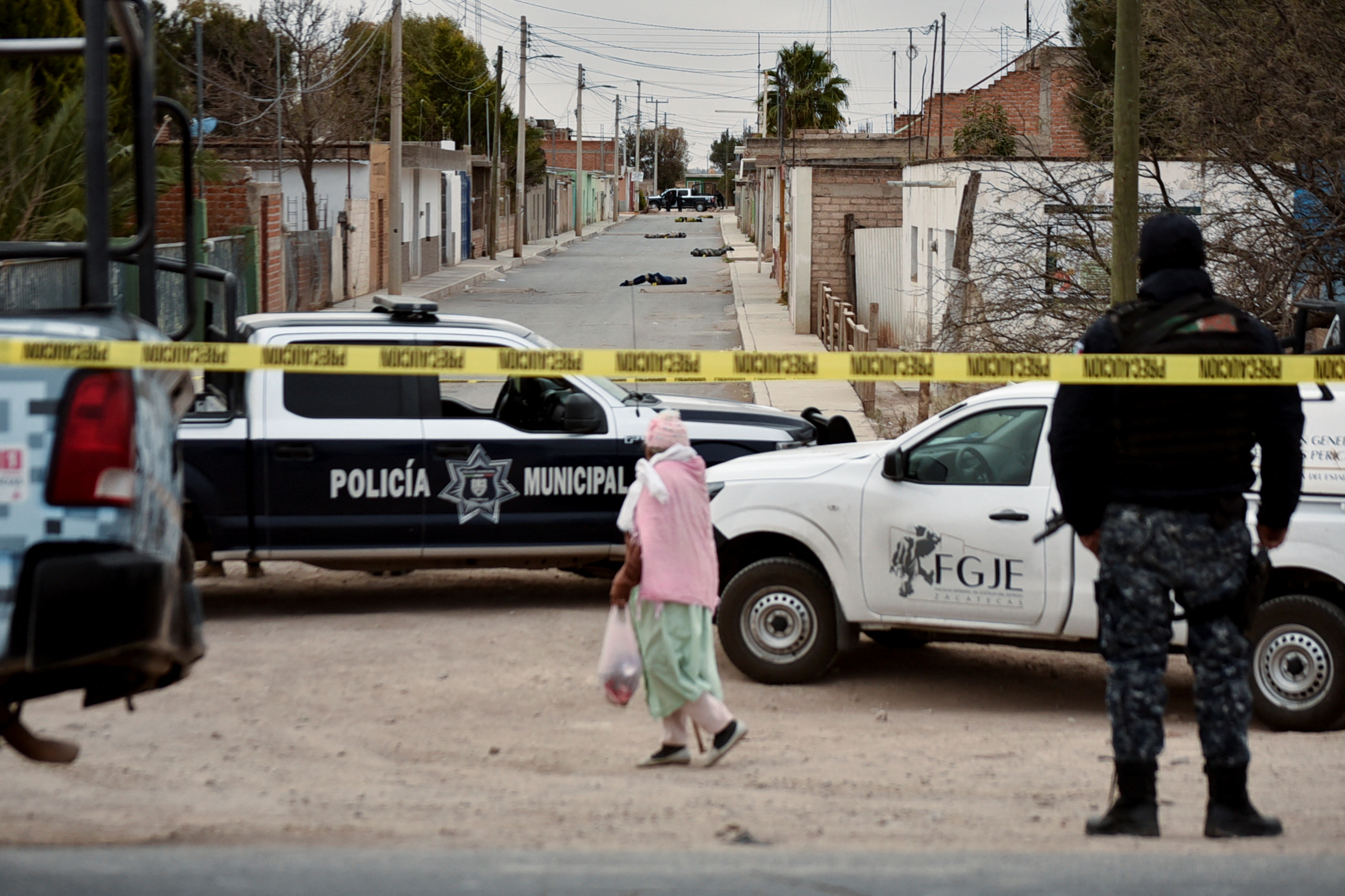 A woman walks at a crime scene where unknown assailants left the bodies of men wrapped in blankets in Fresnillo, Zacatecas state, Mexico February 5, 2022. REUTERS/Edgar Chavez NO RESALES. NO ARCHIVES