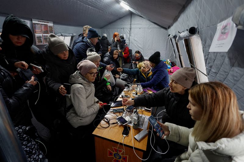 Residentes cargan sus dispositivos, utilizan la conexión a Internet y se calientan dentro de un "centro invencible"en Kiev (REUTERS/Valentyn Ogirenko)