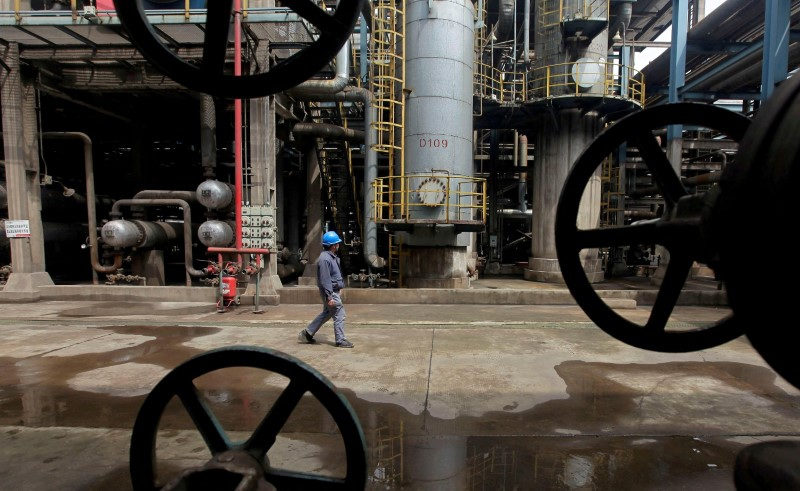 FOTO DE ARCHIVO. Un trabajador pasa por delante de las tuberías de petróleo en una refinería en Wuhan, provincia de Hubei, China. 23 de marzo de 2012. REUTERS/Stringer
