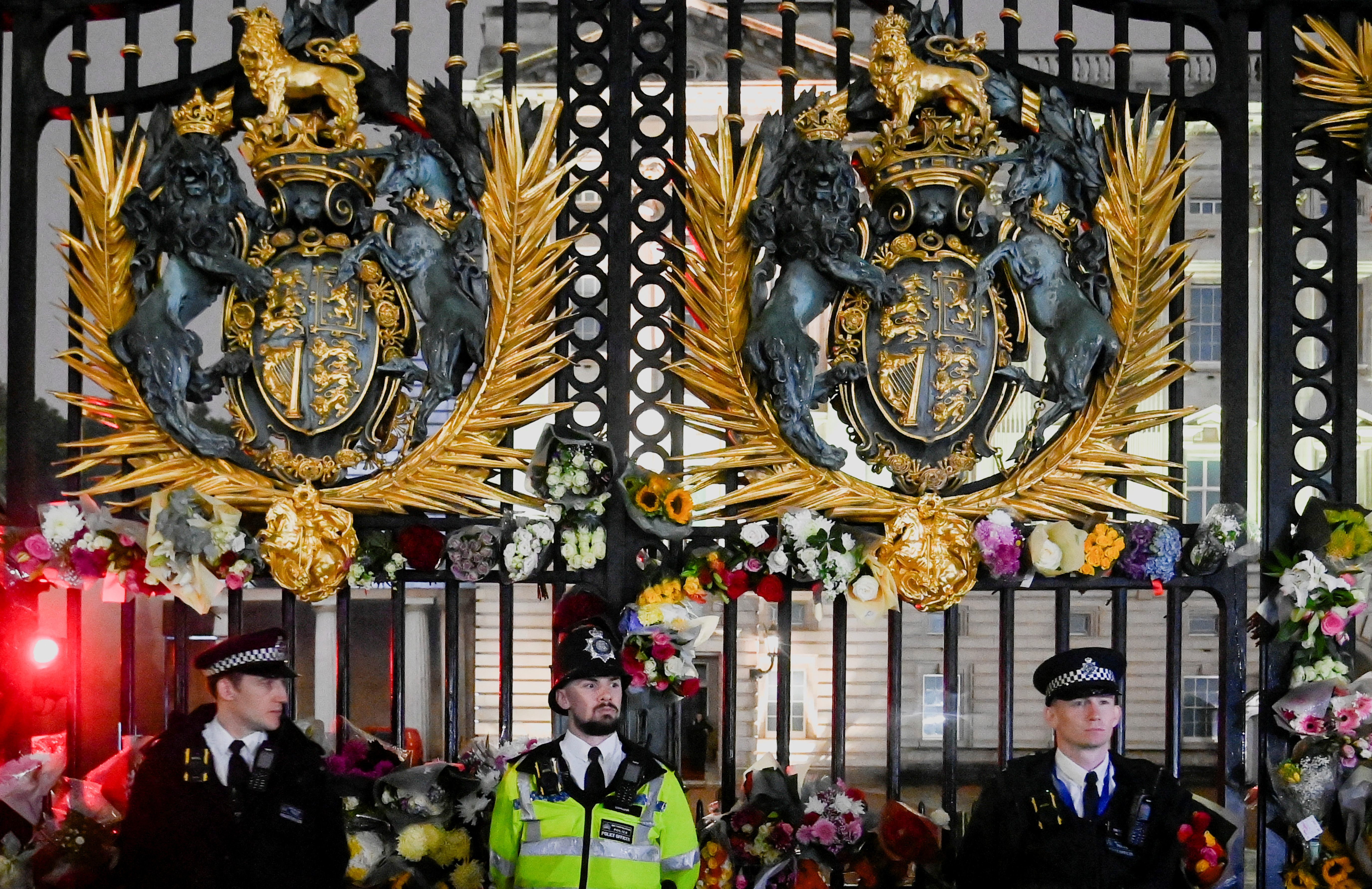 Agentes de policía montan guardia mientras se depositan flores en la puerta del Palacio de Buckingham (REUTERS/Toby Melville)