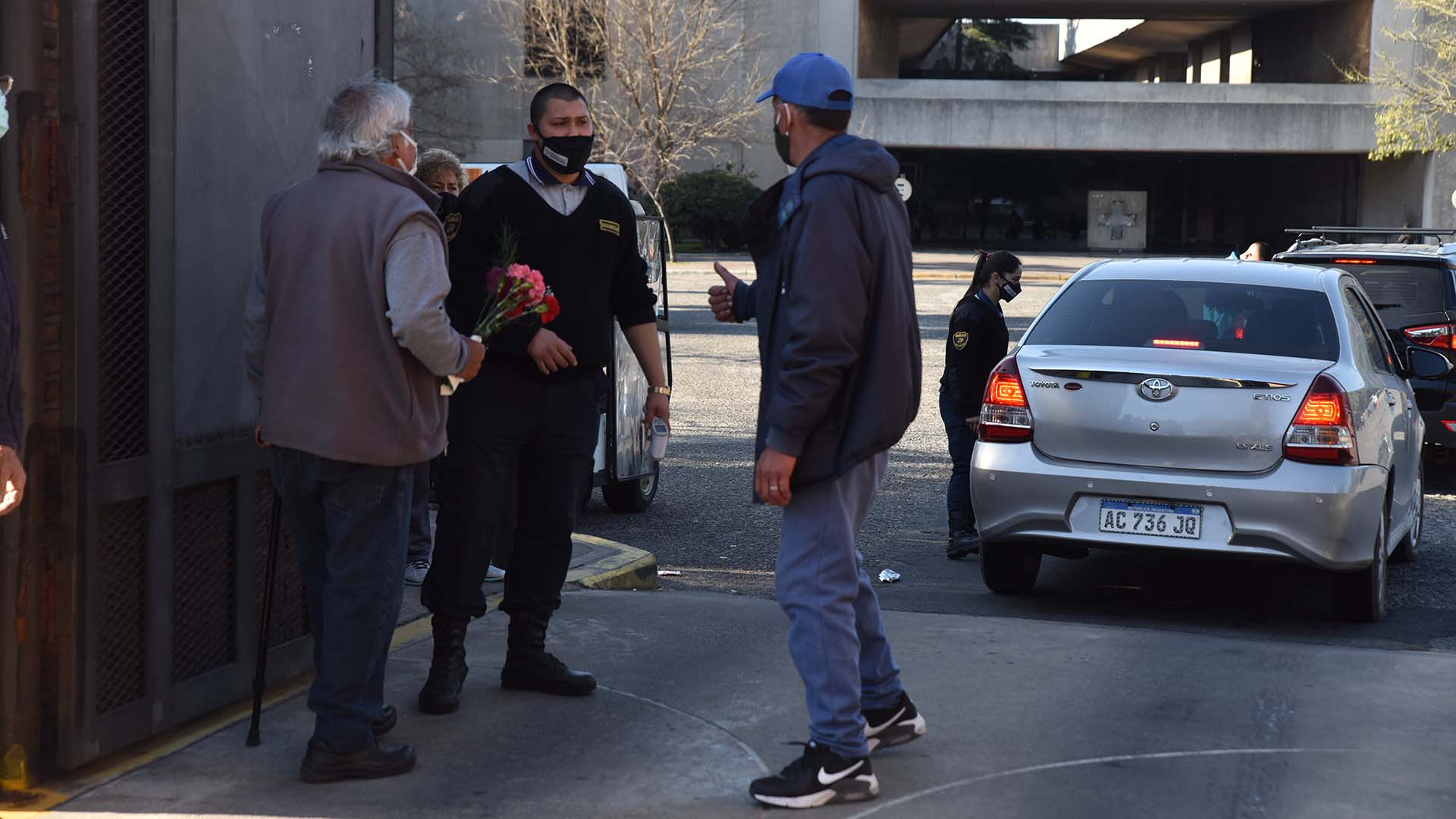 Personal de seguridad toma la temperatura de cada visitante