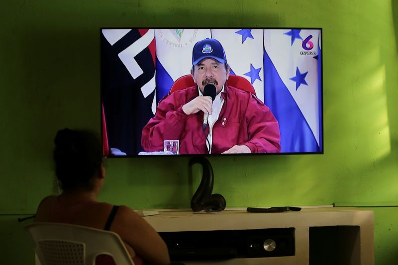 Una mujer viendo en Managua un discurso del dictador de Nicaragua, Daniel Ortega
