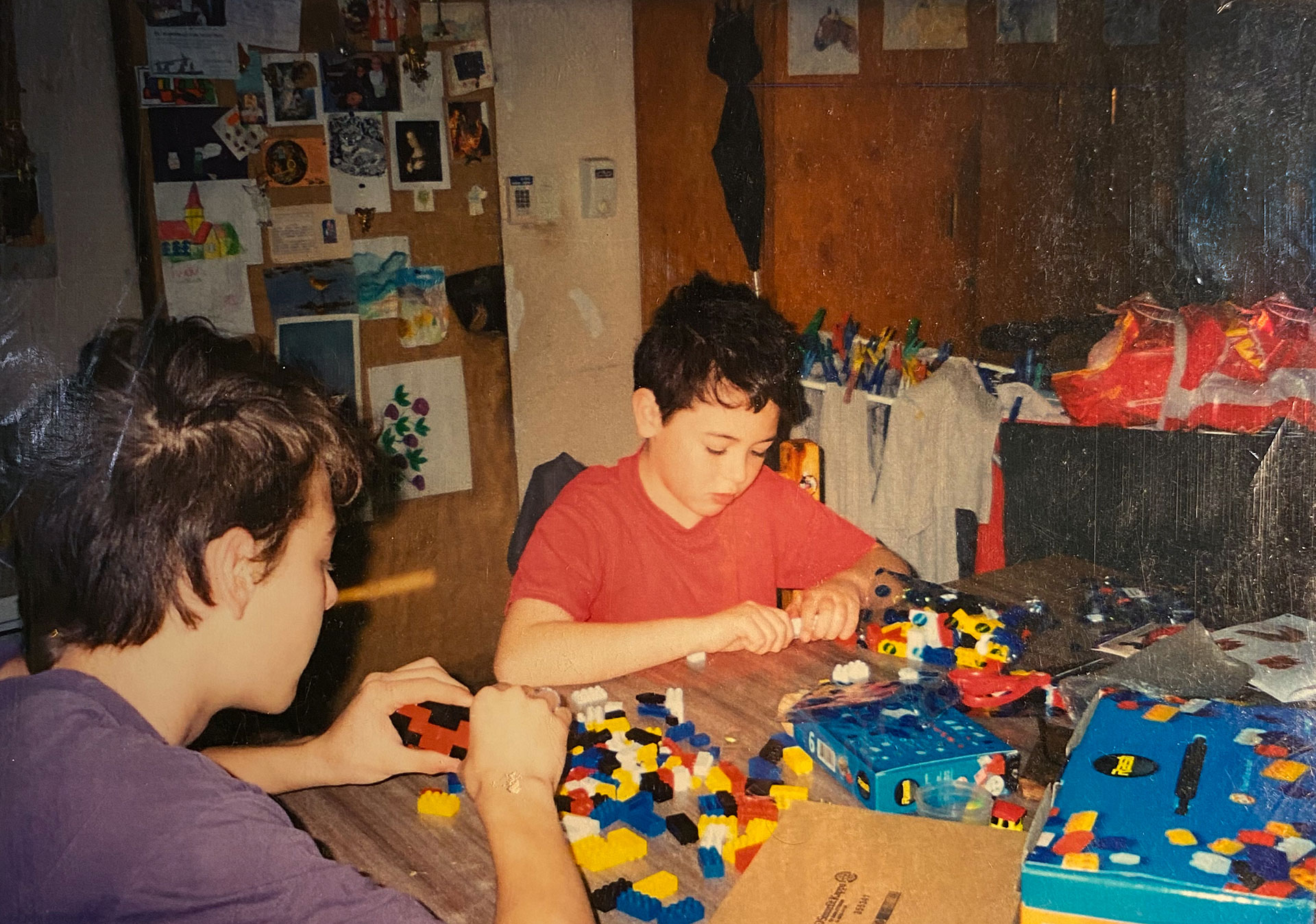 Agustín, de remera roja, jugando con su hermano a construir casas, su obsesión