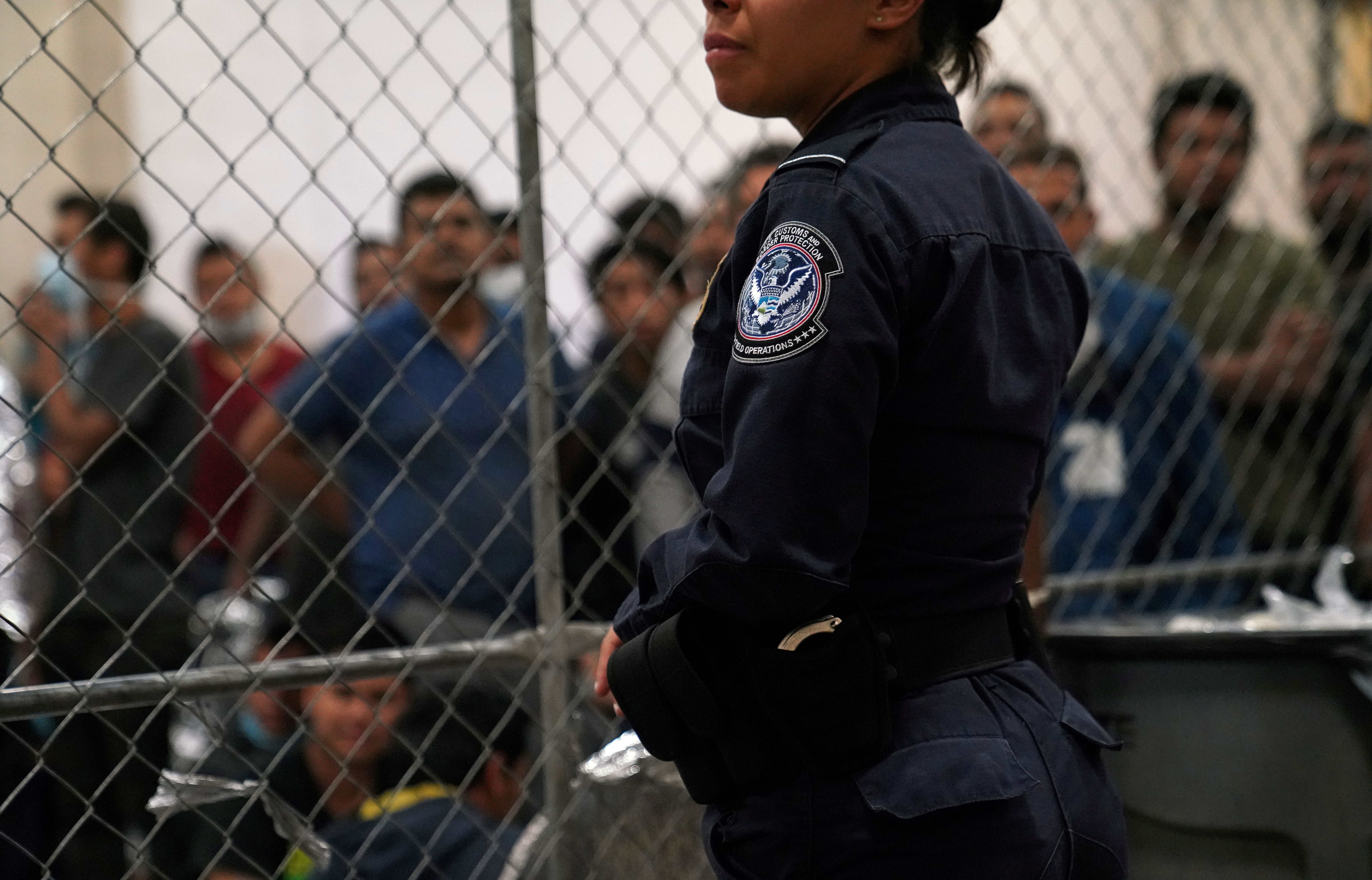 ¿Una agente de la Oficina de Aduanas y Protección Fronteriza de Estados Unidos vigila a hombres detenidos en la estación de la Patrulla Fronteriza en McAllen, Texas, el 12 de julio de 2019.  REUTERS/Veronica G. Cardenas