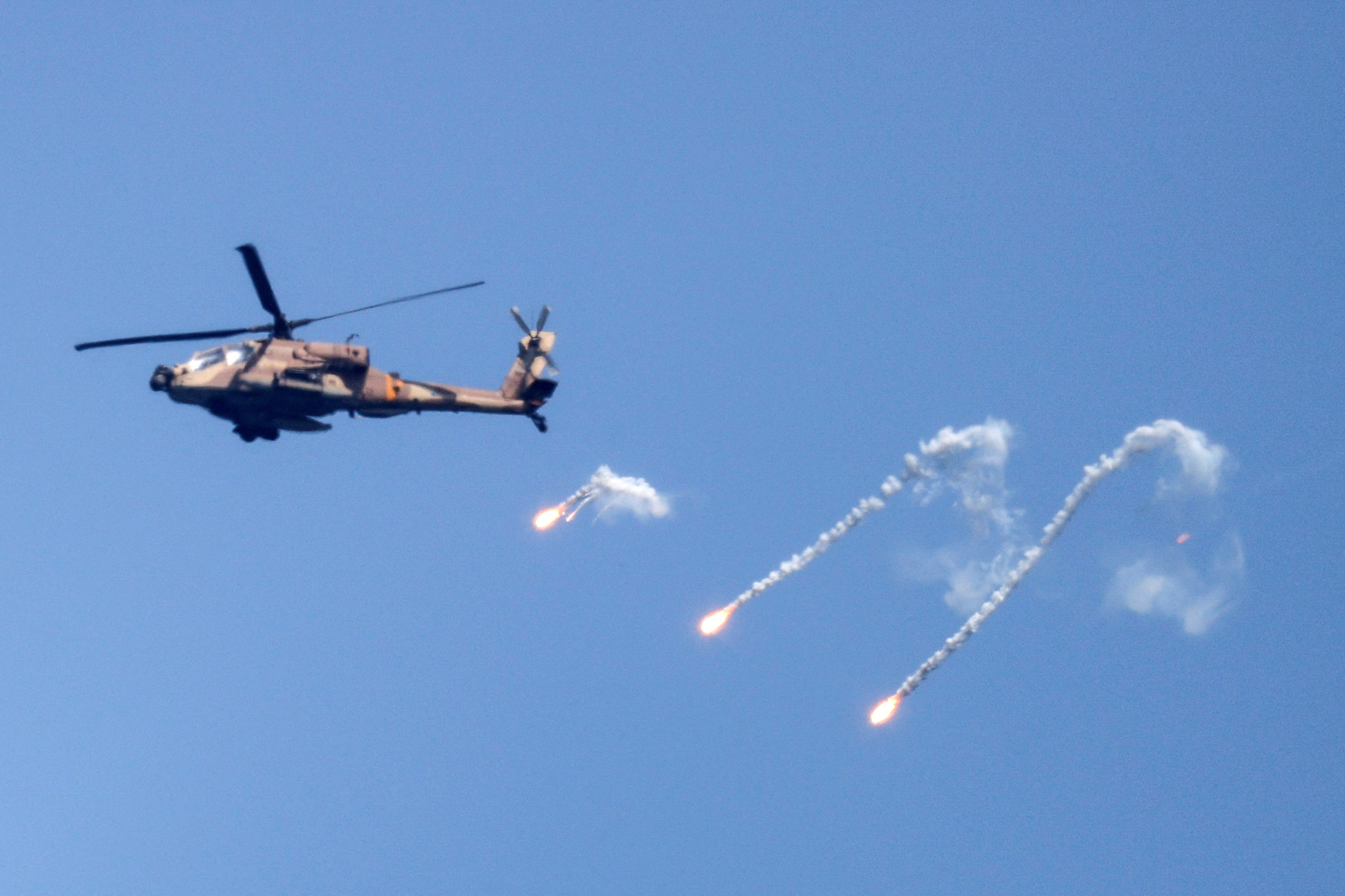 An Israeli Air Force Apache helicopter fires flares in the sky above the Israel-Gaza border