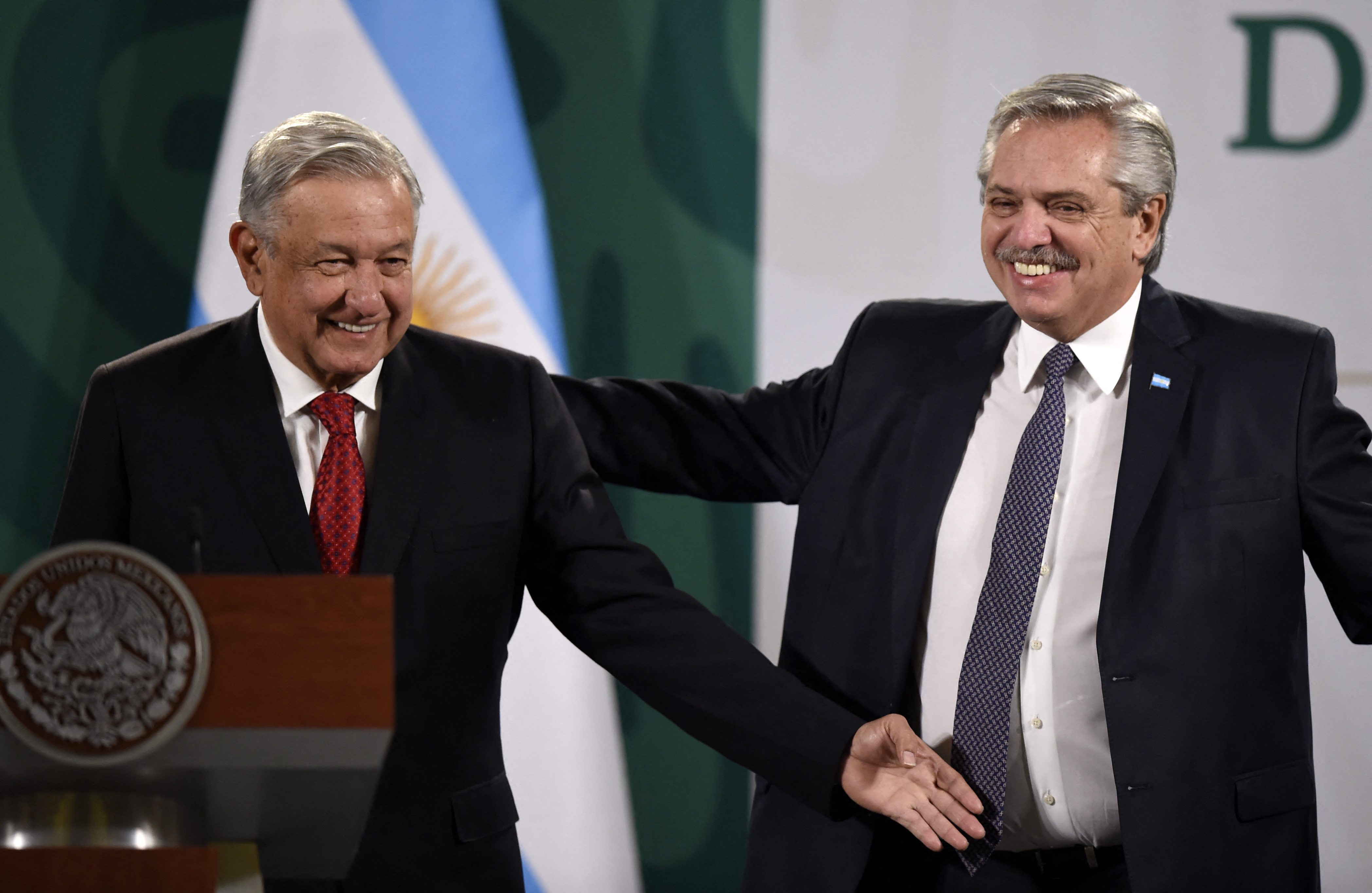 El presidente mexicano, Andrés Manuel López Obrador y su homólogo argentino, Alberto Fernández, hacen un gesto mientras se preparan para ofrecer una conferencia de prensa conjunta en la Ciudad de México el 23 de febrero de 2021.
