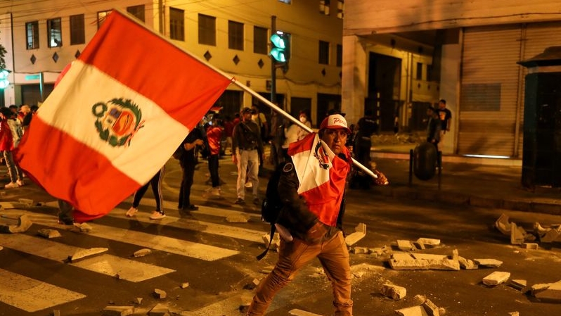 A protester carries the flag of Peru during a protest demanding the dissolution of Congress and the celebration of democratic elections in the place of recognition of Dina Boluarte as president of Peru, after the removal of the Peruvian leader Pedro Castillo, in Lima, Peru, on the 11 December 2022. REUTERS/Sebastian Castaneda