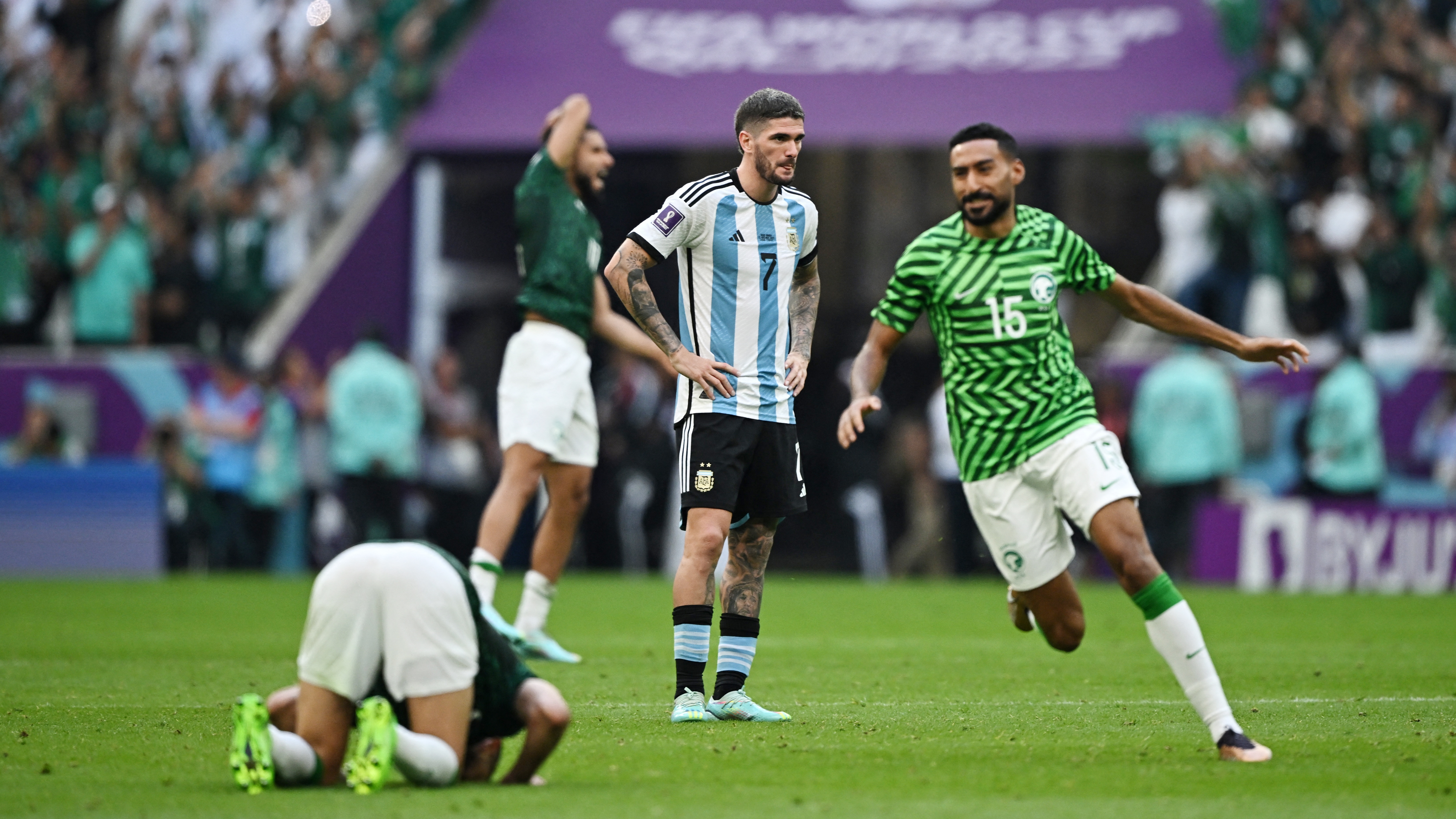 Rodrigo De Paul sufre y Ali Al-Hassan celebra la victoria de Arabia Saudita.  El resultado obliga a cambios para el técnico argentino (REUTERS/Dylan Martinez)