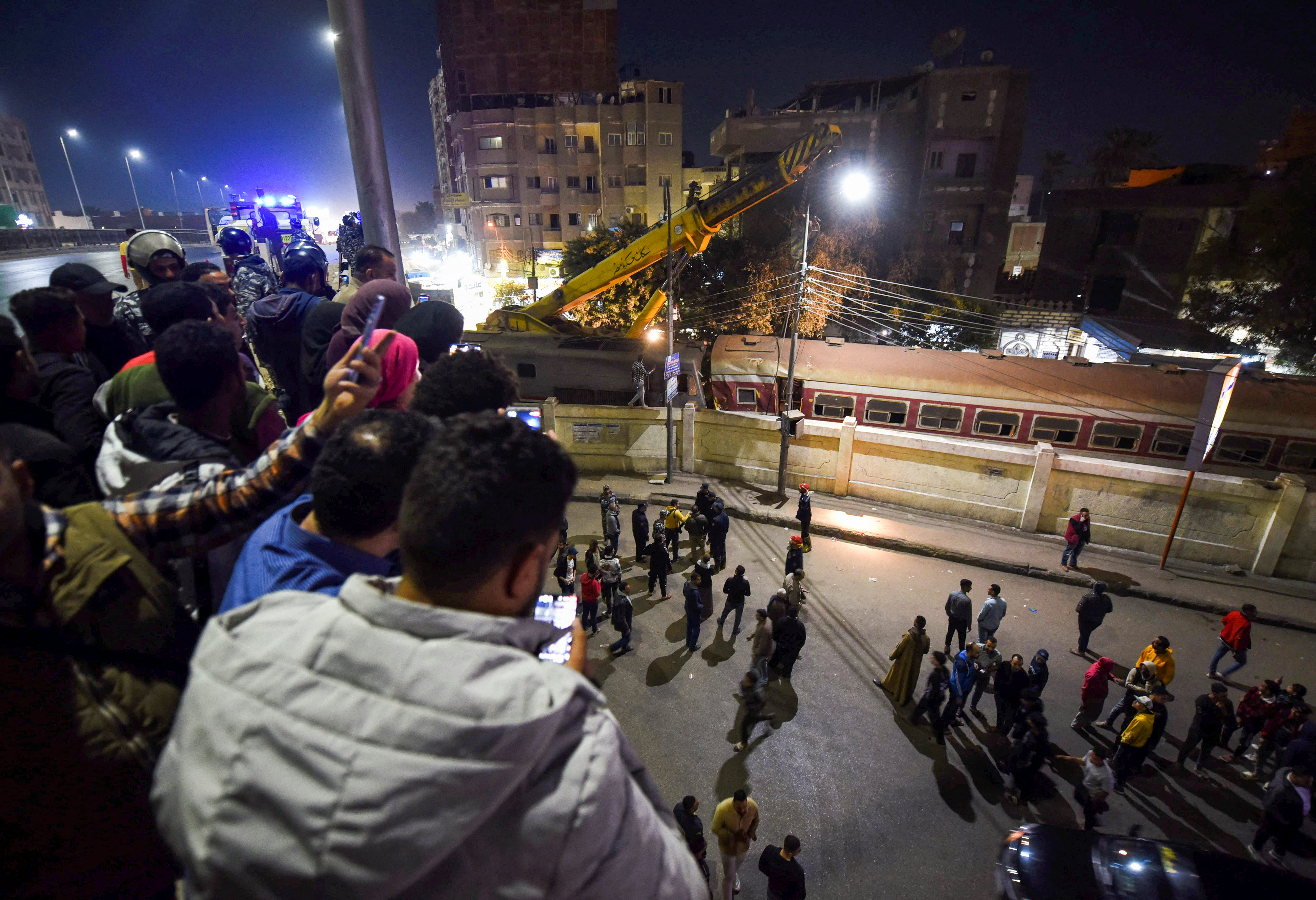 Vecinos observan cómo las autoridades rescatan a las personas atrapadas en los vagones del tren accidentado (REUTERS/Shokry Hussien)