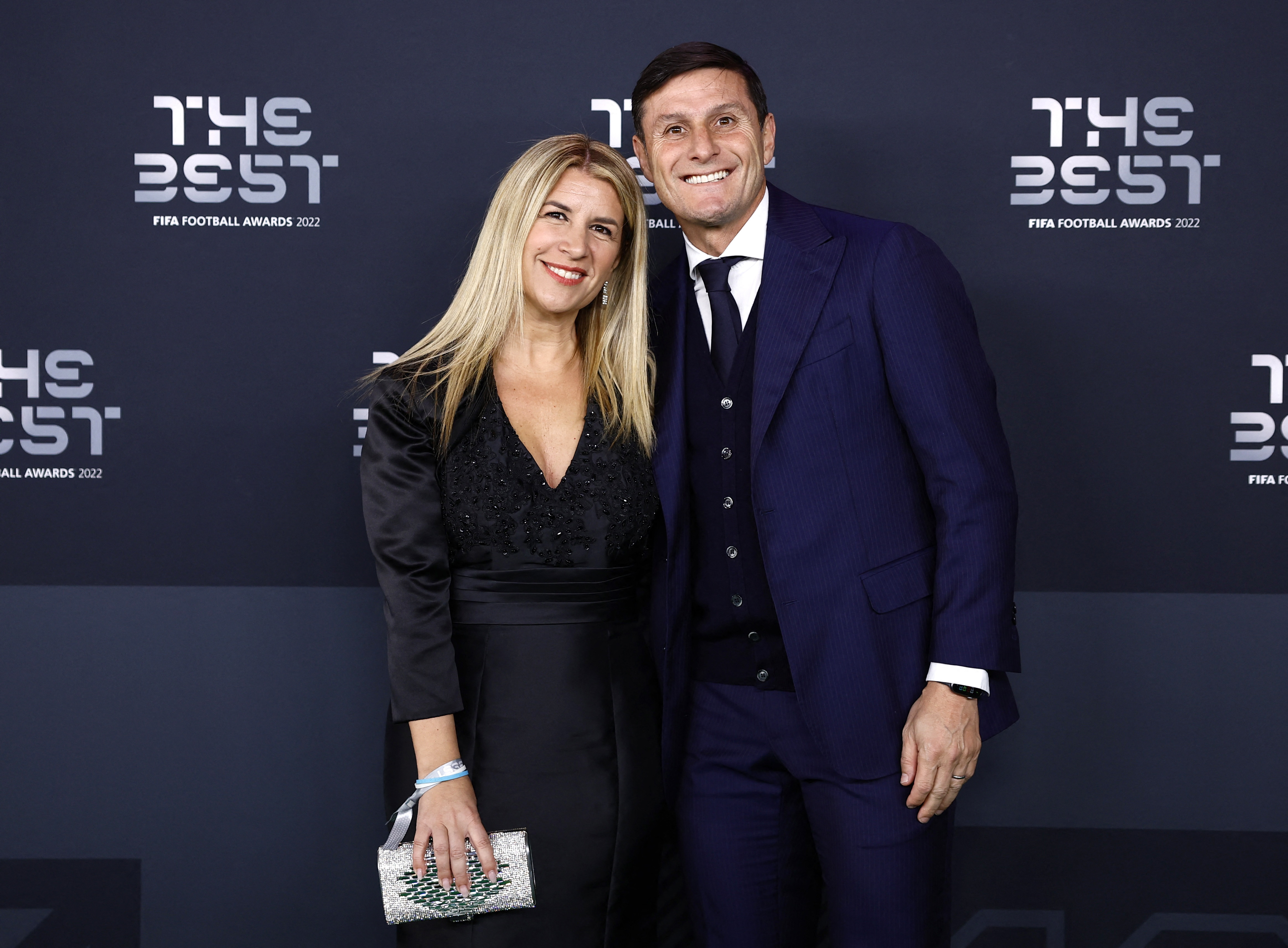 El "Pupi" Zanetti pasó por la alfombra verde con un traje azul marino que combinó con un chaleco cerrado de tonos oscuros y camisa blanca. Su esposa, Paula, eligió un vestido negro escotado combinado con una cartera tipo sobre de color plateado a tono con su brazalete /REUTERS