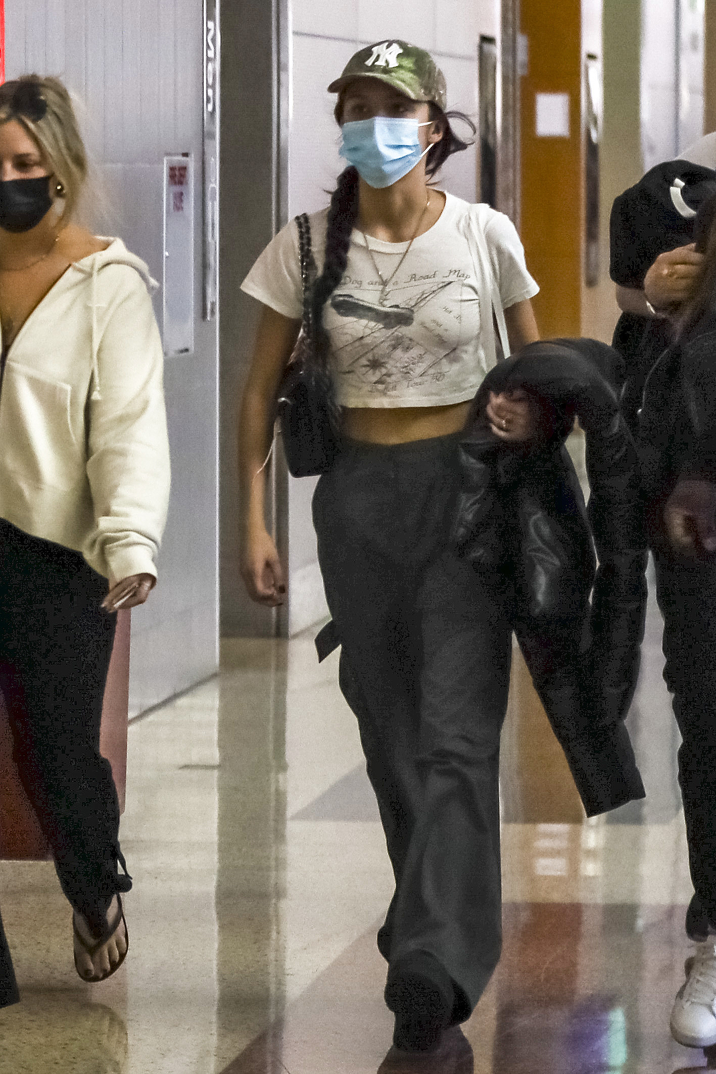 Olivia Rodrigo was photographed at the Las Vegas airport as she was leaving the city.  She wore a comfortable look for traveling: gray cotton pants, a white printed shirt, a feather jacket and a leather bag.  Also, she wore a mask.