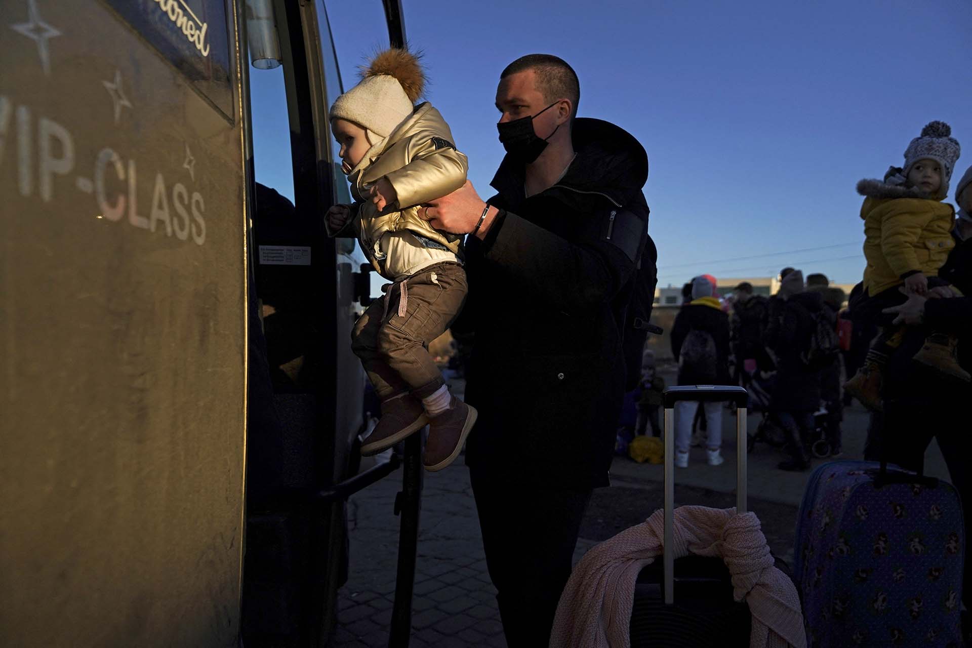 Un niño, cuya familia acababa de huir de la violencia en Ucrania, es subido a un autobús para ser transportado lejos de la frontera, en Medyka, Polonia.