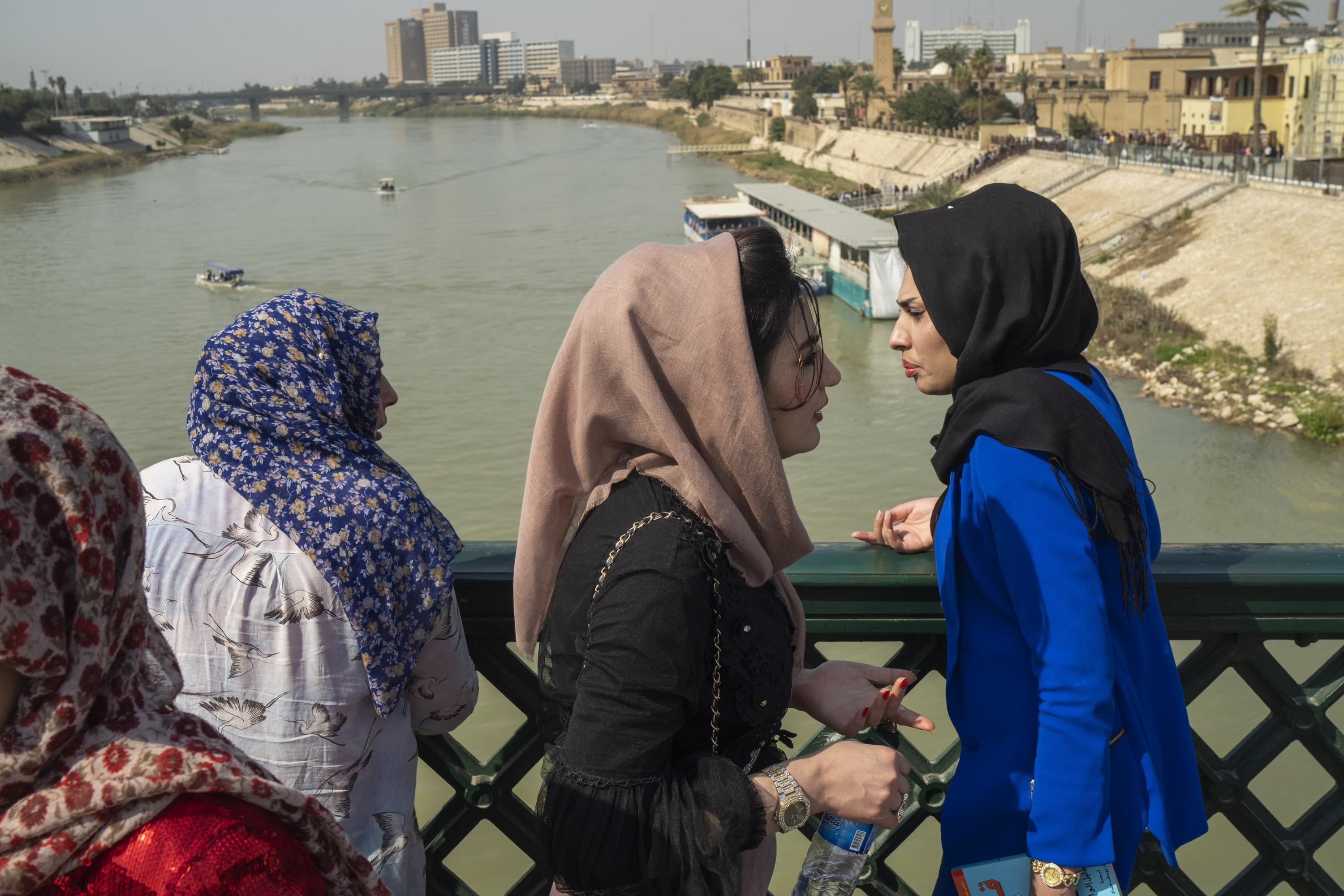 Un grupo de mujeres cruza el "puente de los mártires" sobre el rìo Tigris cuando se cumplen 20 años desde la caída del régimen de Saddam Hussein y la invasión estadounidense. (Jerome Delay/AP)