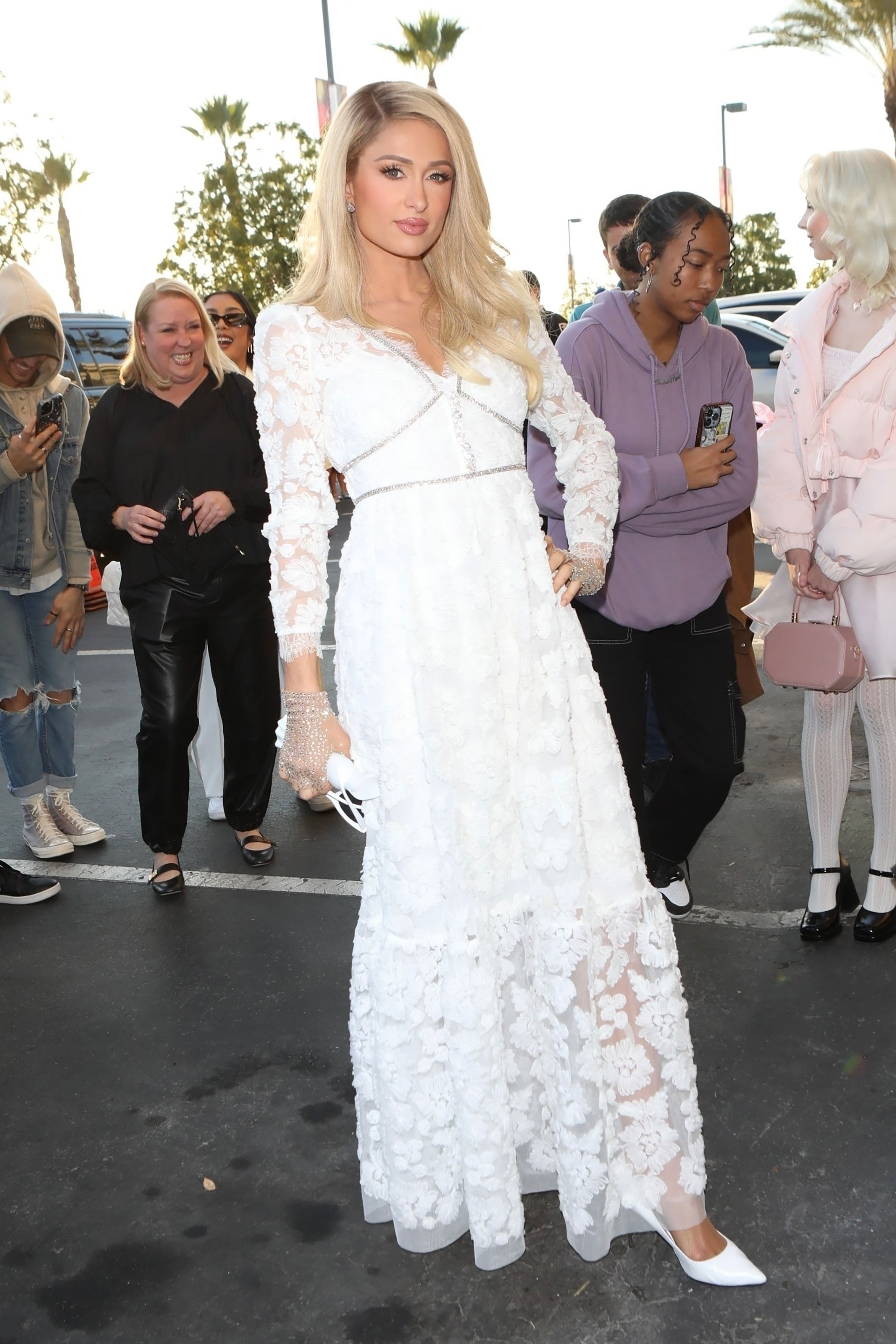 Paris Hilton lanzó su fragancia número 29 "Love Rush", en una celebración que tuvo lugar en Nordstrom Rack, Riverside, California. Lució espléndida con un vestido blanco de encaje transparente y su icónica melena rubia bien acomodada hacia un lado. Combinó el atuendo con lentes de sol de marco blanco estilo gato