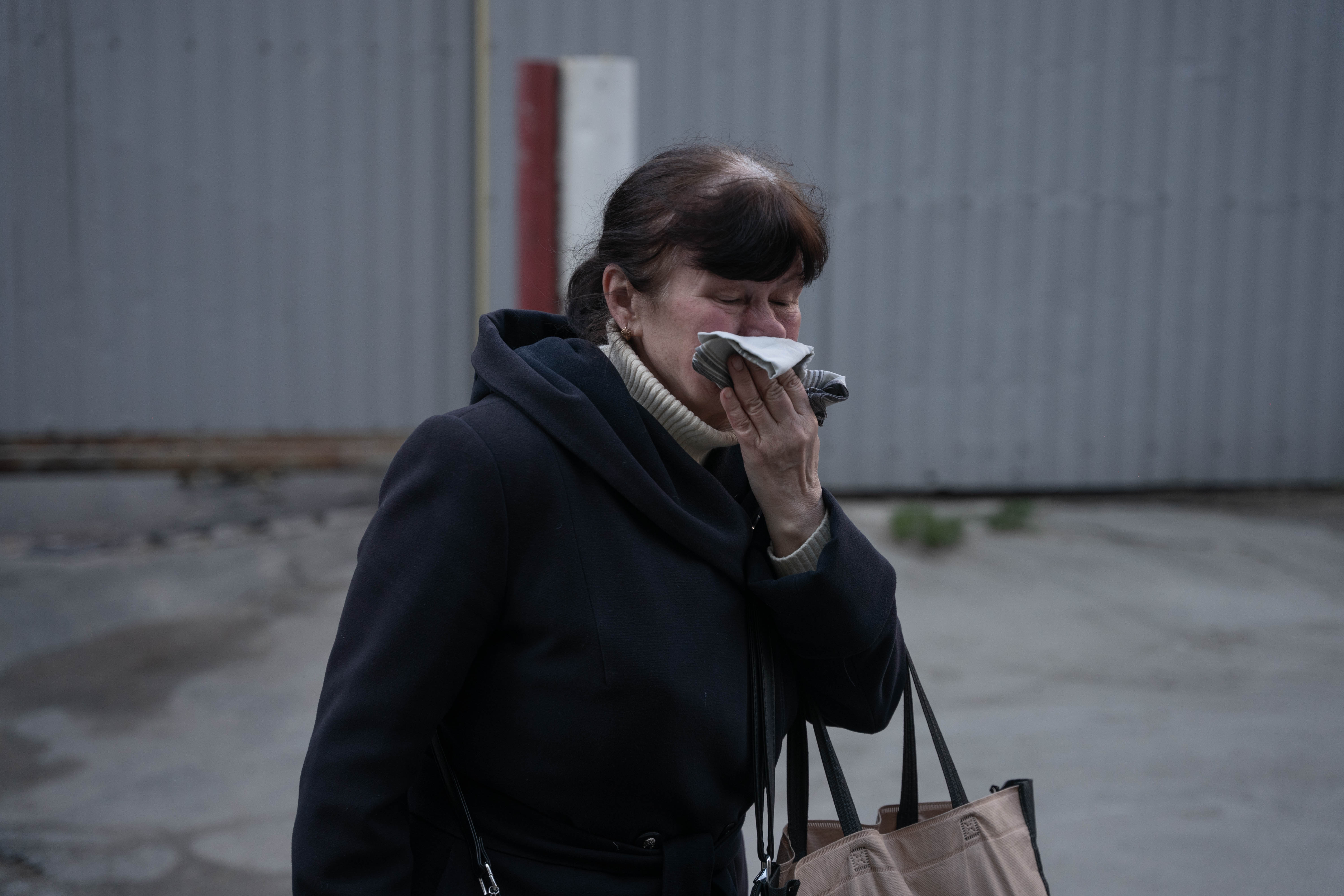 Una mujer se emociona hasta las lagrimas al pasar frente a los destrozos.